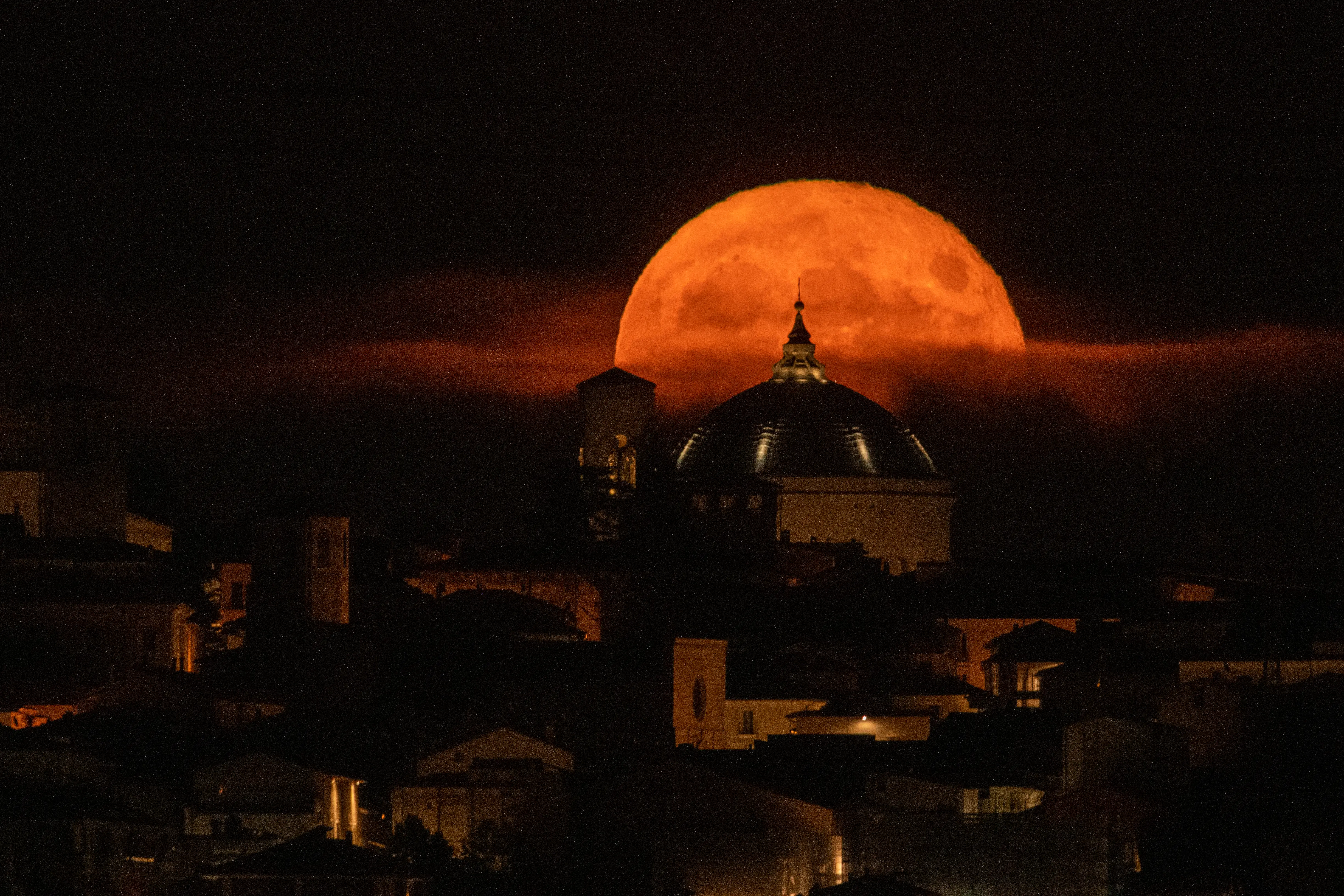 A sturgeon Super Moon rising behind San Bernardino church dome in L'Aquila (Abruzzo, Italy), on august 12, 2022. August full moon is the last supermoon of  2022. (Photo by Lorenzo Di Cola/NurPhoto via Getty Images)