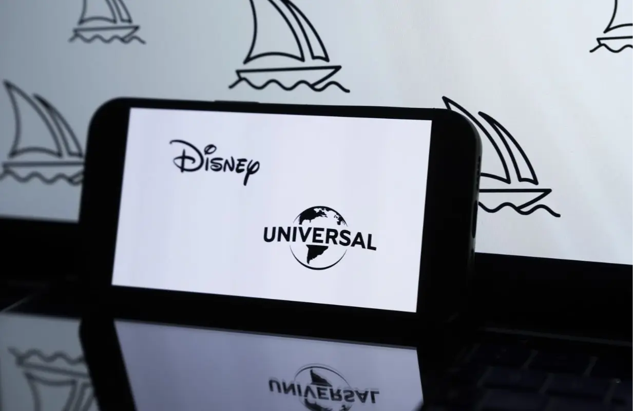 Photo illustration of Disney &amp; Universal logos (Image via Getty)