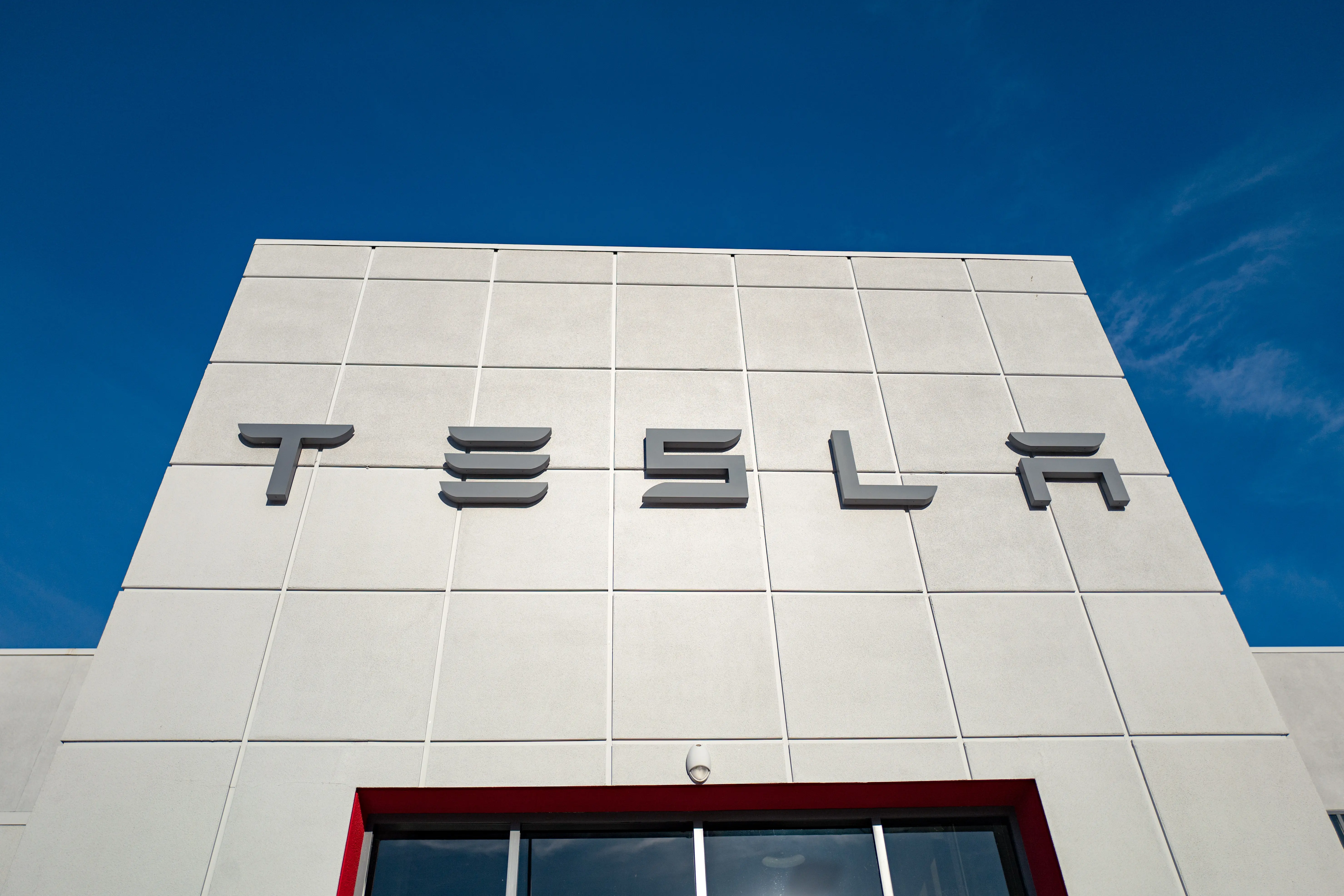 Low-angle view of the facade of Tesla Motors dealership with logo and sign in Pleasanton, California, July 23, 2018. (Photo by Smith Collection/Gado/Getty Images)