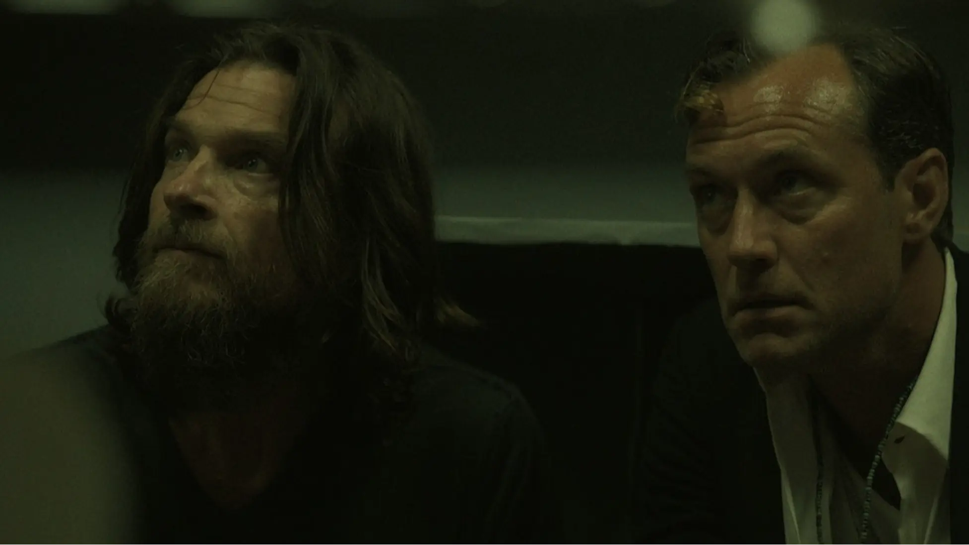 Jude Law as Jake Friedken and Jason Bateman as Vince crouch under harsh light as pressure mounts around their New York hotspot. Image Courtesy: Netflix. 