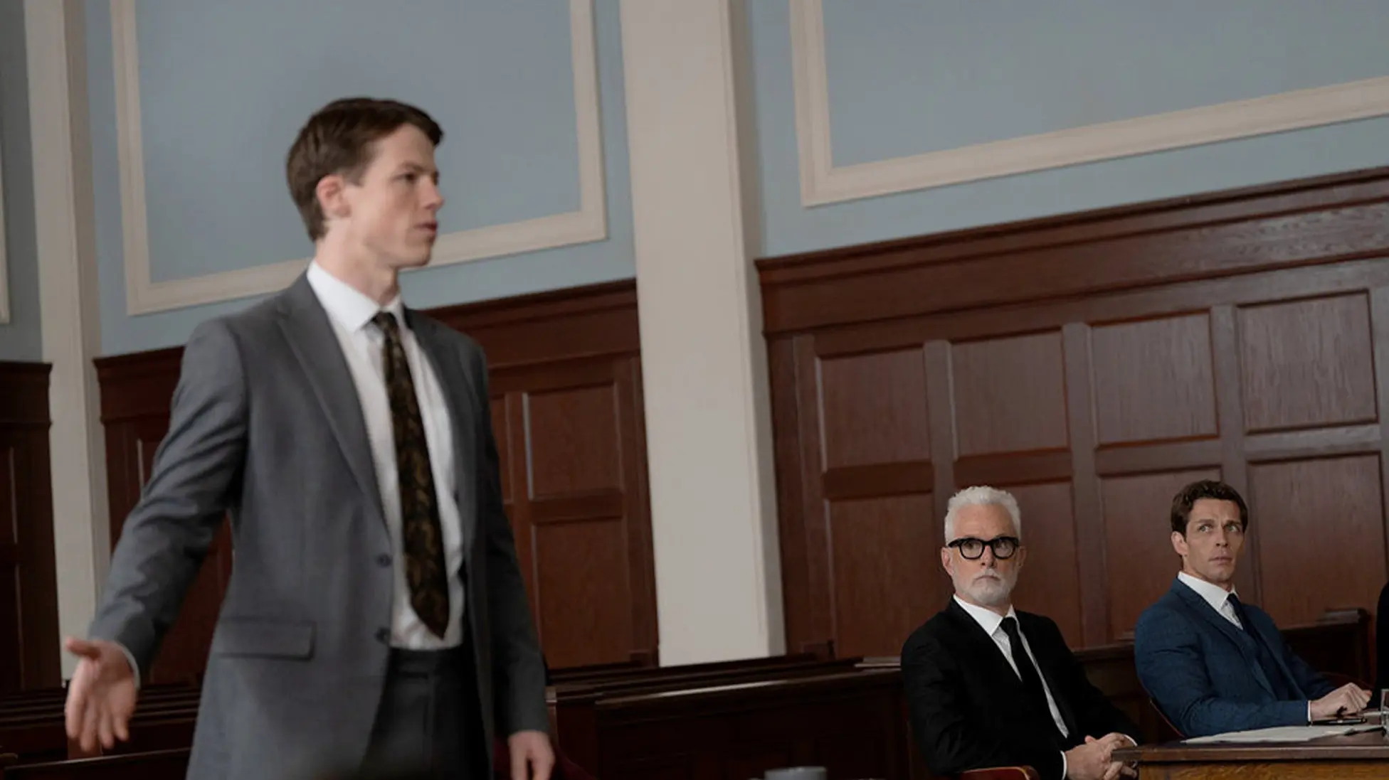 Milo Callaghan as Rudy Baylor (left) argues before the judge as John Slattery’s Leo Drummond watches from counsel table in The Rainmaker Episode 2, Nashville Hot. (Image via USA networks)