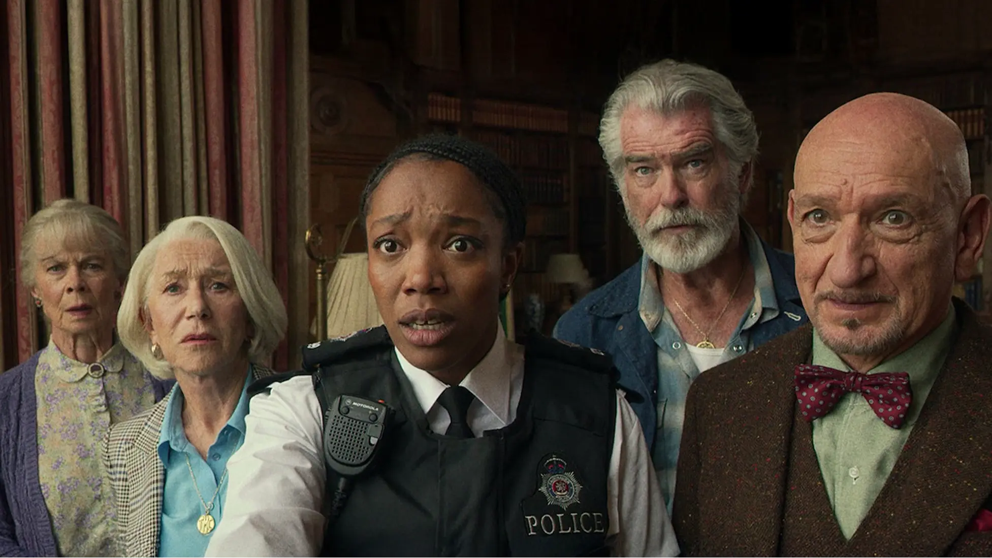 Celia Imrie (Joyce), Helen Mirren (Elizabeth), Naomi Ackie (PC Donna de Freitas), Pierce Brosnan (Ron), and Ben Kingsley (Ibrahim) in The Thursday Murder Club. Image Courtesy of Netflix.