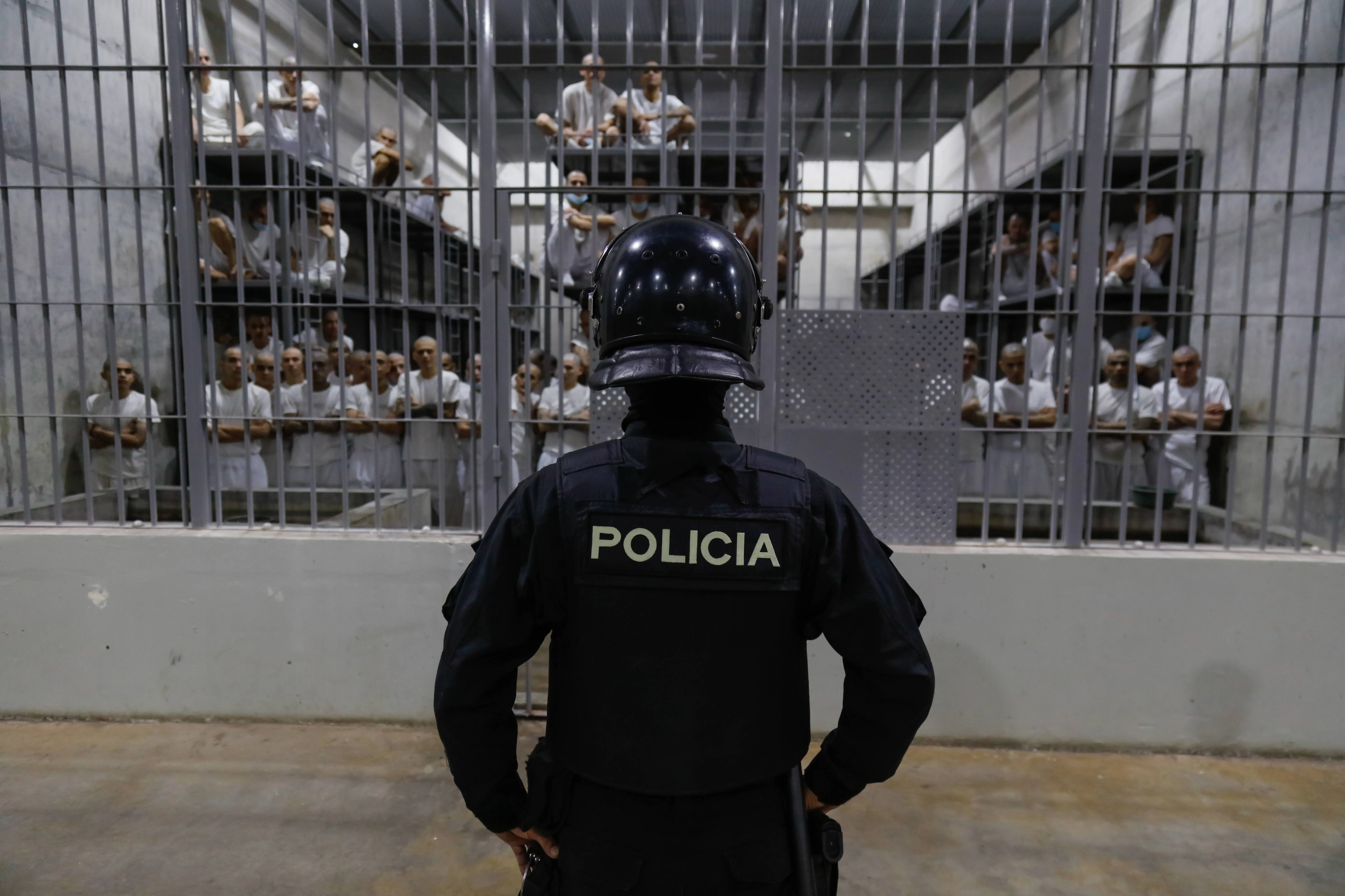 An officer in riot gear stands on patrol inside a cell at CECOT in Tecoluca (Image via Getty)