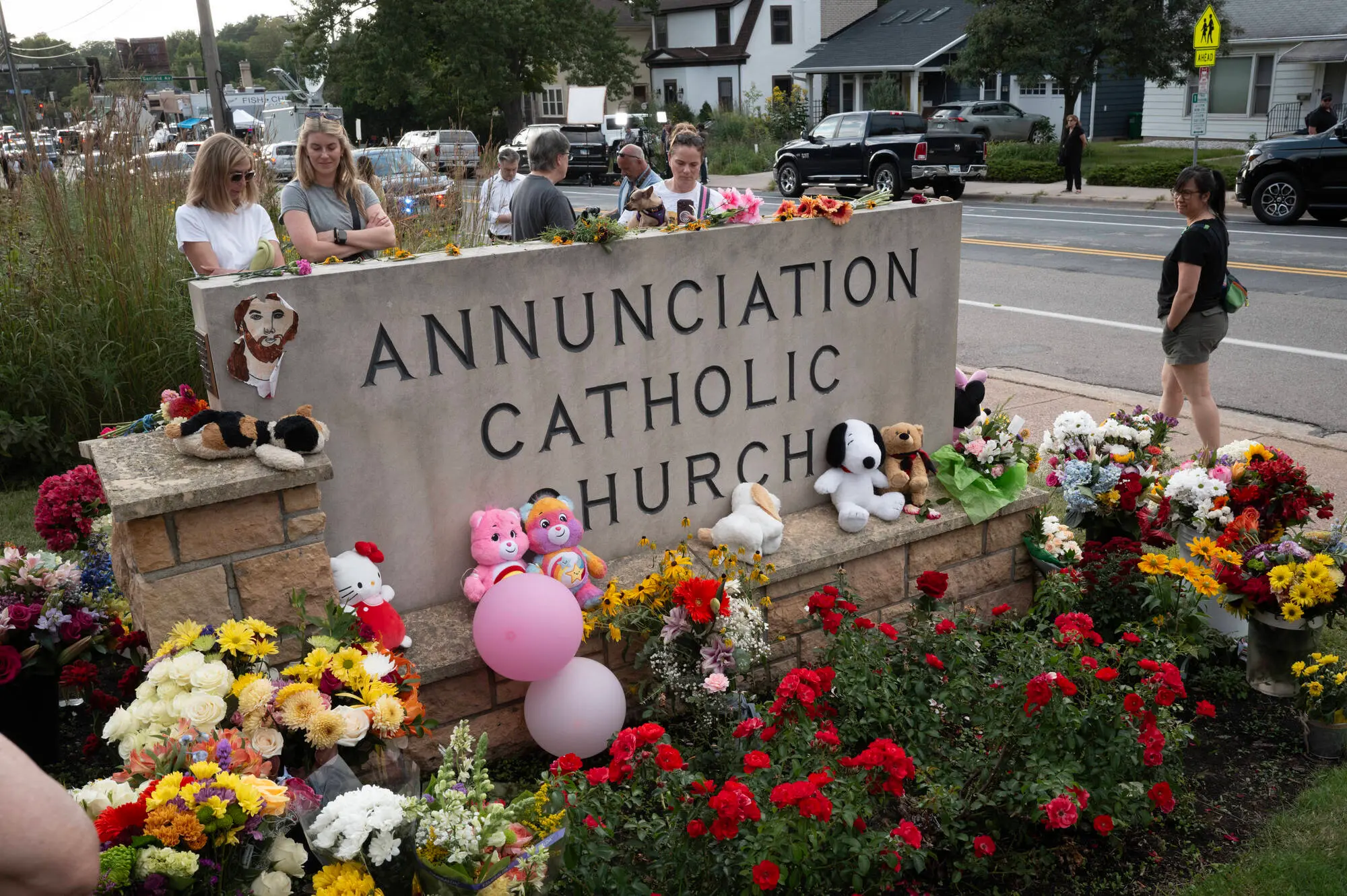 People leave flowers and other mementoes in front of Annunciation Catholic Church, a rapidly growing memorial to the victims of yesterday's shooting on August 28, 2025 in Minneapolis, Minnesota. (Photo by Scott Olson/Getty Images)