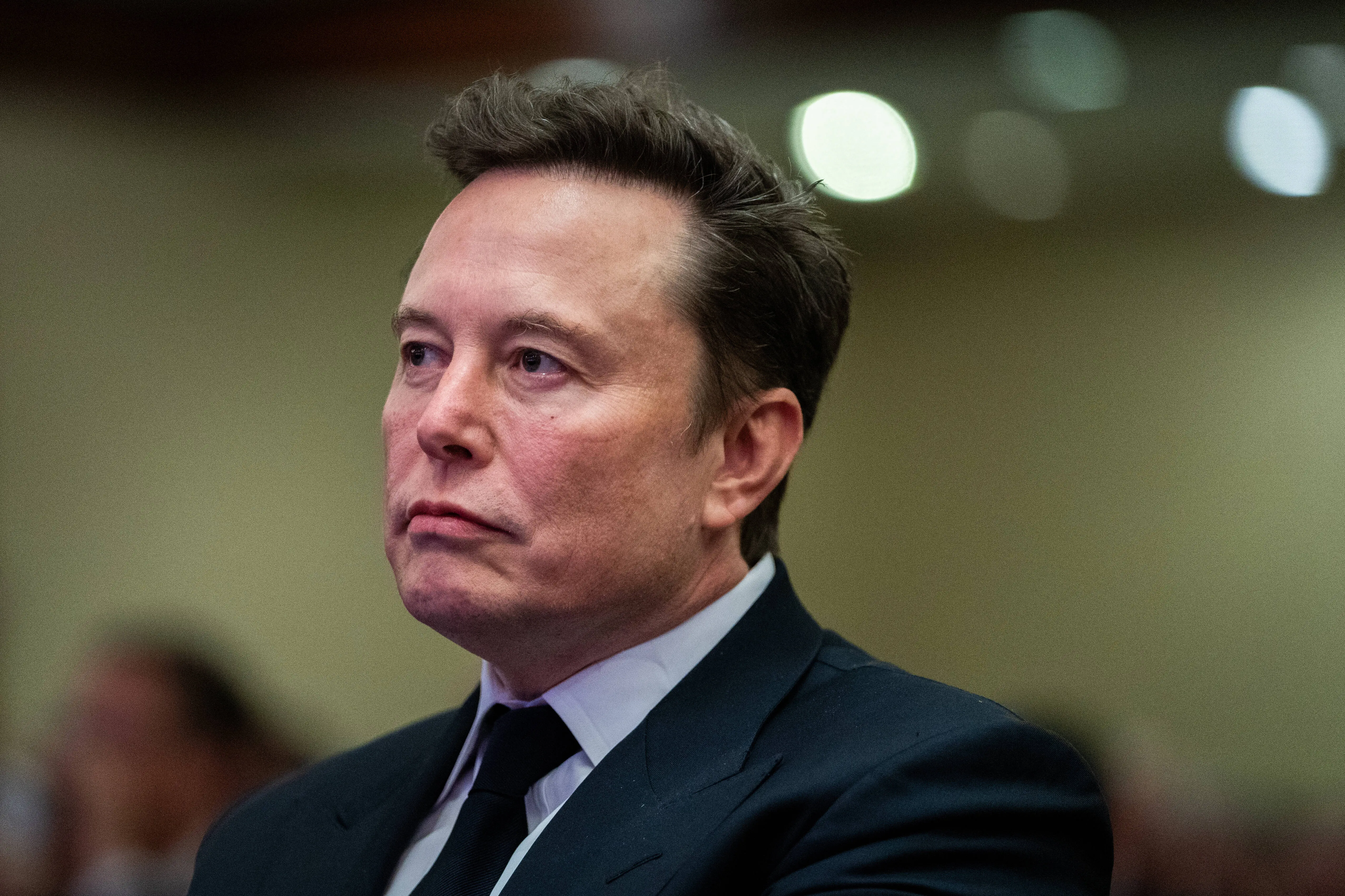 Elon Musk listens as US President-elect Donald Trump speaks during a House Republicans Conference meeting at the Hyatt Regency on Capitol Hill on November 13, 2024 in Washington, DC. (Photo by Allison Robbert-Pool/Getty Images)