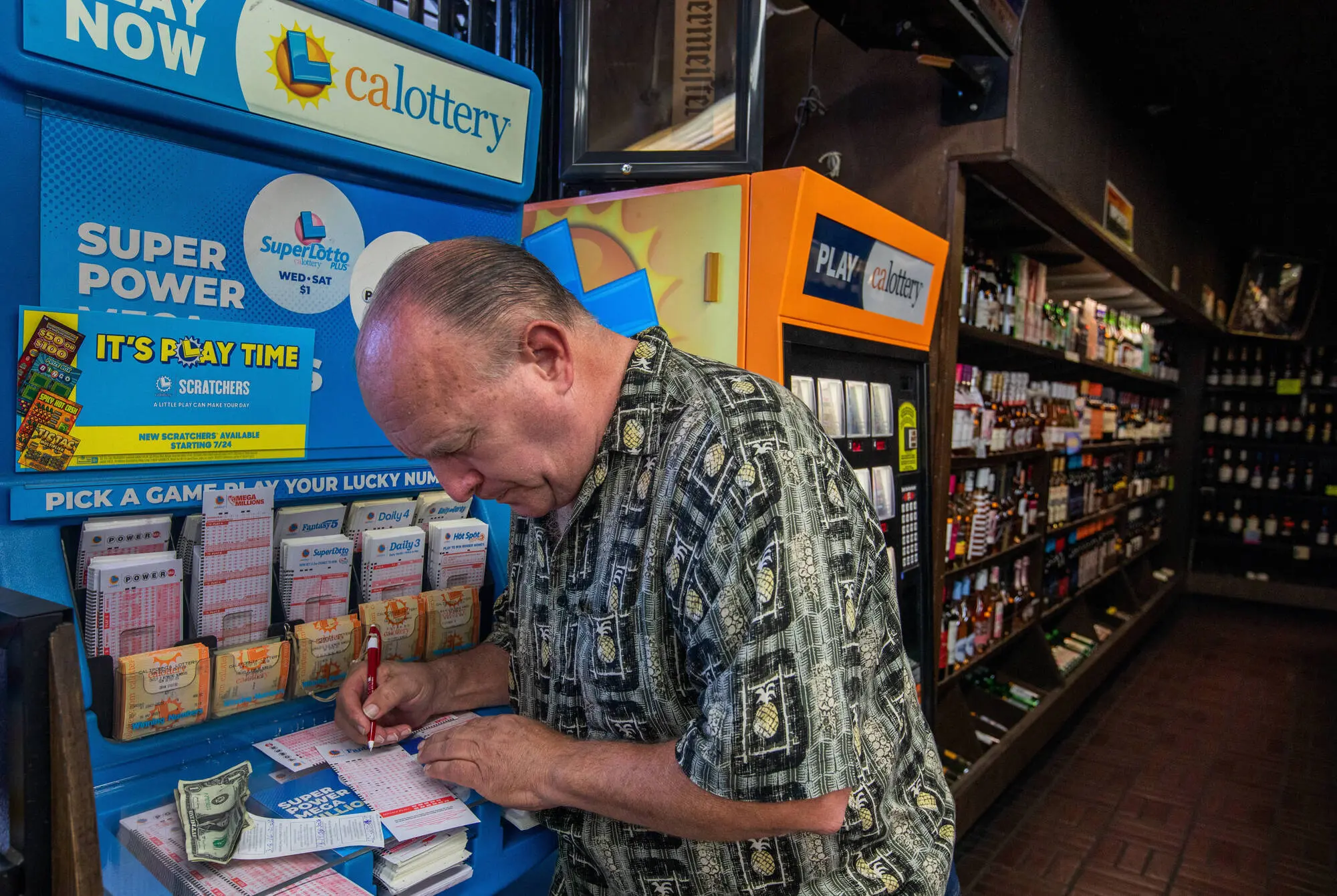 South Pasadena, CA - October 01:  Lewis Hensley, 62, of Highland Park purchases a lotto ticket at Foremost Liquor Store on Sunday, Oct. 1, 2023, in South Pasadena, CA. The Powerball lottery has reached the 1 billion mark with an estimated $1.04 billion jackpot, for the next drawing on Monday night after no grand prize winner in Saturday's drawing.  (Francine Orr / Los Angeles Times via Getty Images)