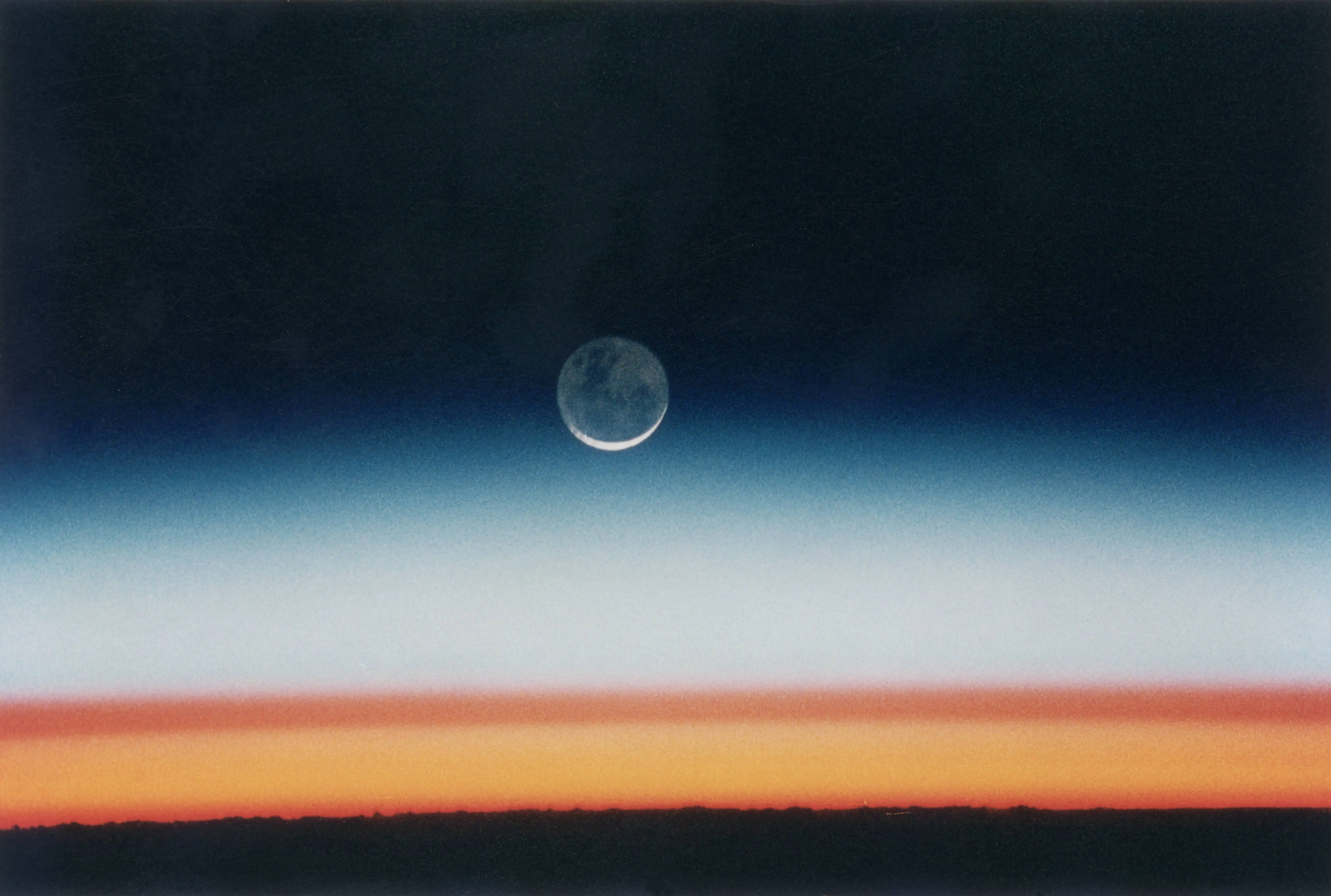 The moon rises over the earth shortly before sunrise, as seen from the space shuttle Columbia during NASA's STS-52 mission, October 1992. The shuttle is orbiting Earth at an altitude of 285 km over Lake Tanganyika in central Africa. The sun is just below the horizon, and the brown layer marks the tropical tropopause. (Photo by Space Frontiers/Getty Images)