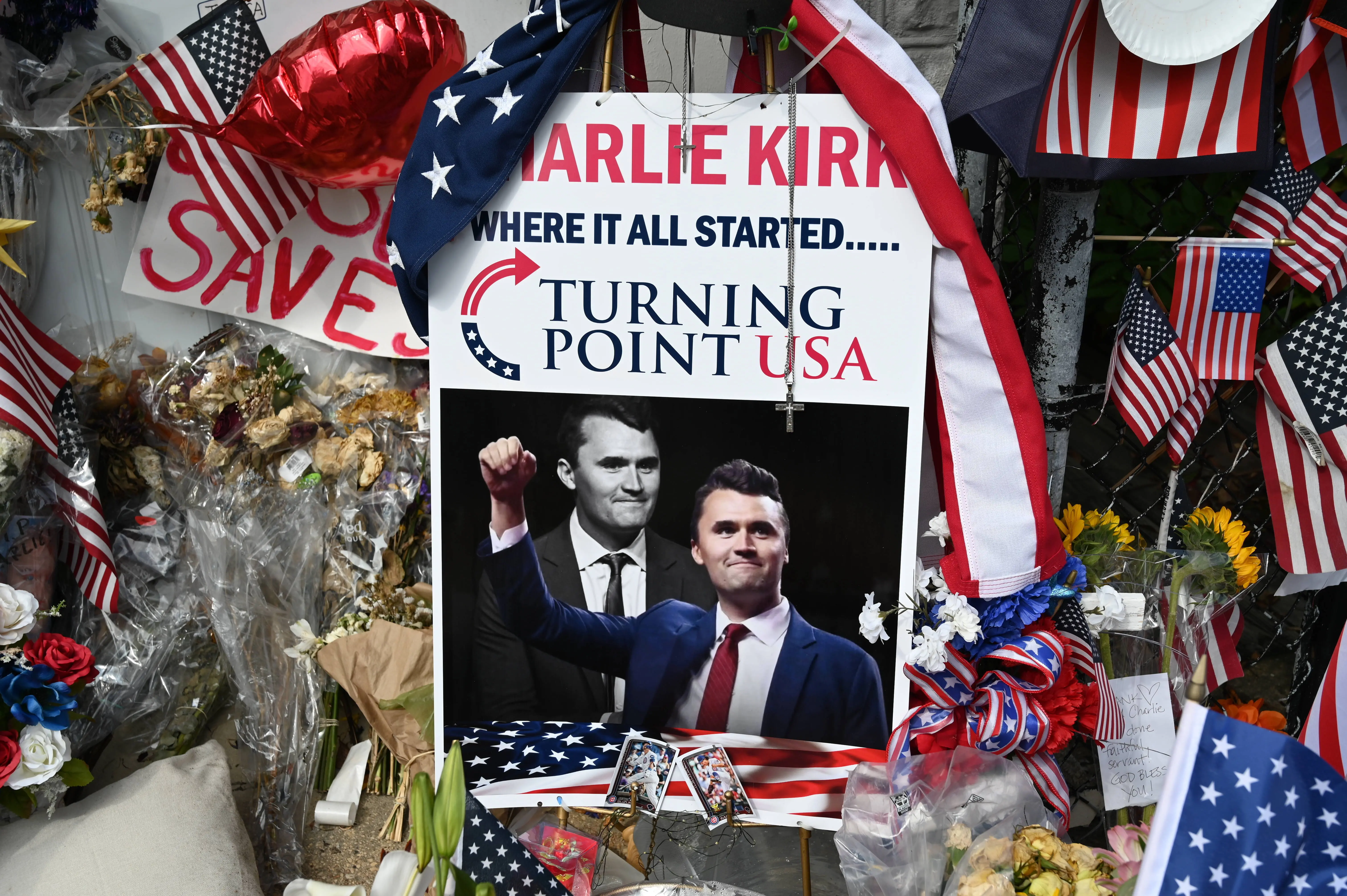 A pile of flowers, candles, and photos placed outside the original Turning Point USA office in Lemont, founded by Charlie Kirk, on Sunday, September 21, 2025, marking the day of his funeral in Illinois, United States. (Photo by Jacek Boczarski/Anadolu via Getty Images)