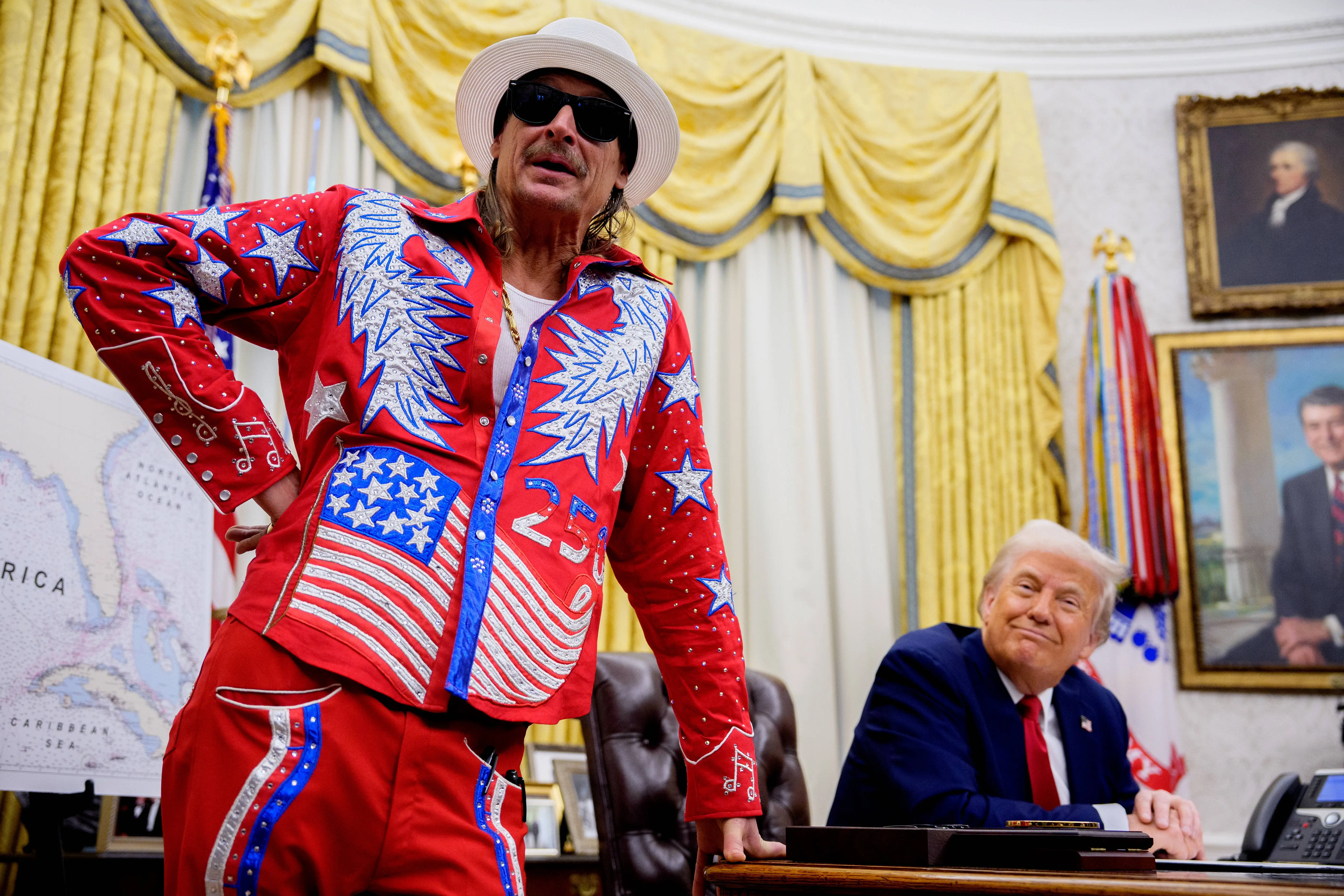 President Donald Trump listens as entertainer Kid Rock speaks during an executive order signing event in the Oval Office of the White House on March 31, 2025 in Washington, DC. (Photo by Andrew Harnik/Getty Images)