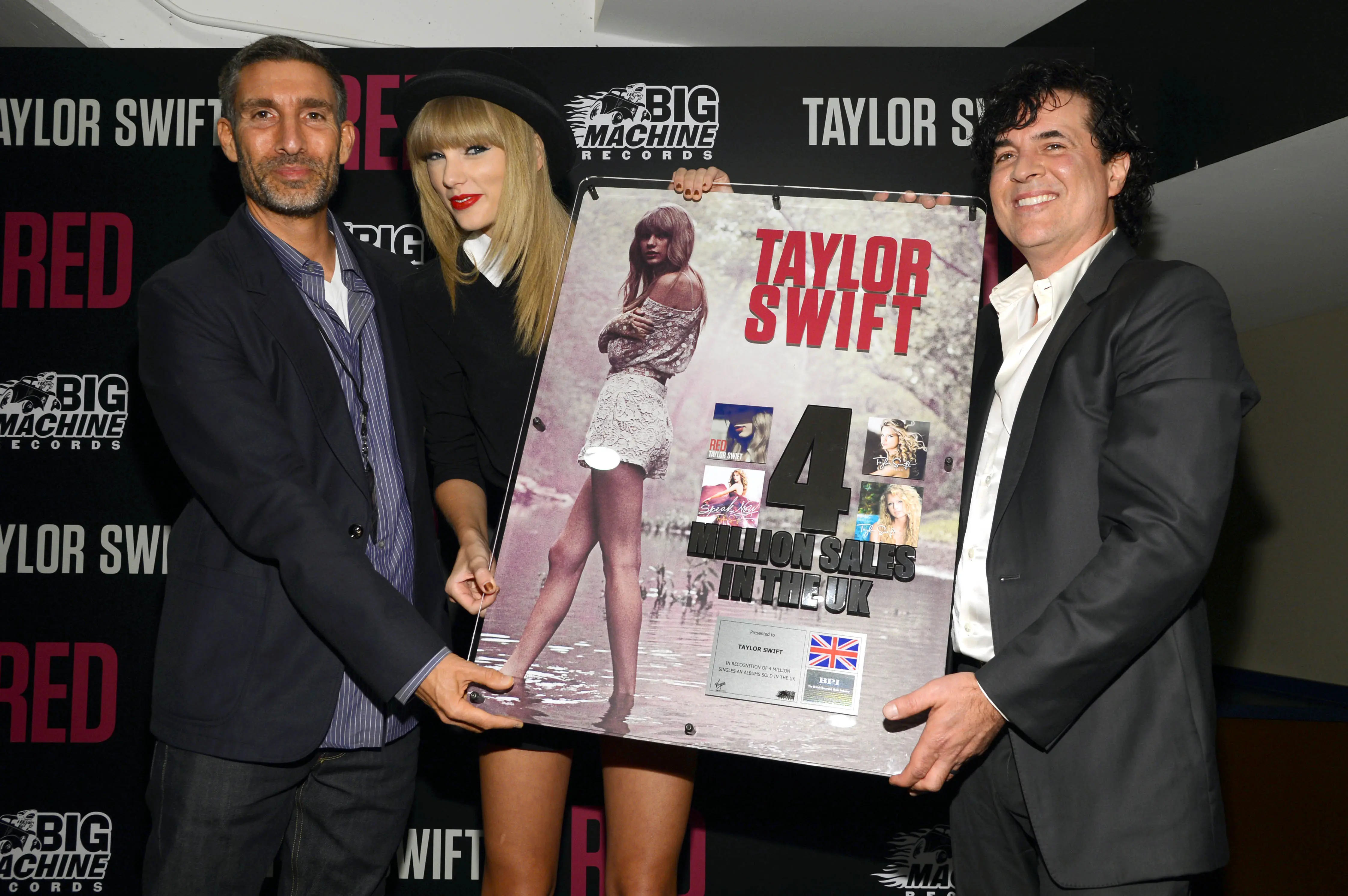 Taylor Swift is honored by Universal Music Group UK CEO and Chairman David Joseph (L) and Big Machine Label Group President and CEO Scott Borchetta (R) for her multi-platinum album RED at a special event during the final 3 nights of her sold-out North American tour on September 19, 2013 at the Bridgestone Arena in Nashville, Tennessee.  (Photo by Larry Busacca/TAS/Getty Images for TAS)