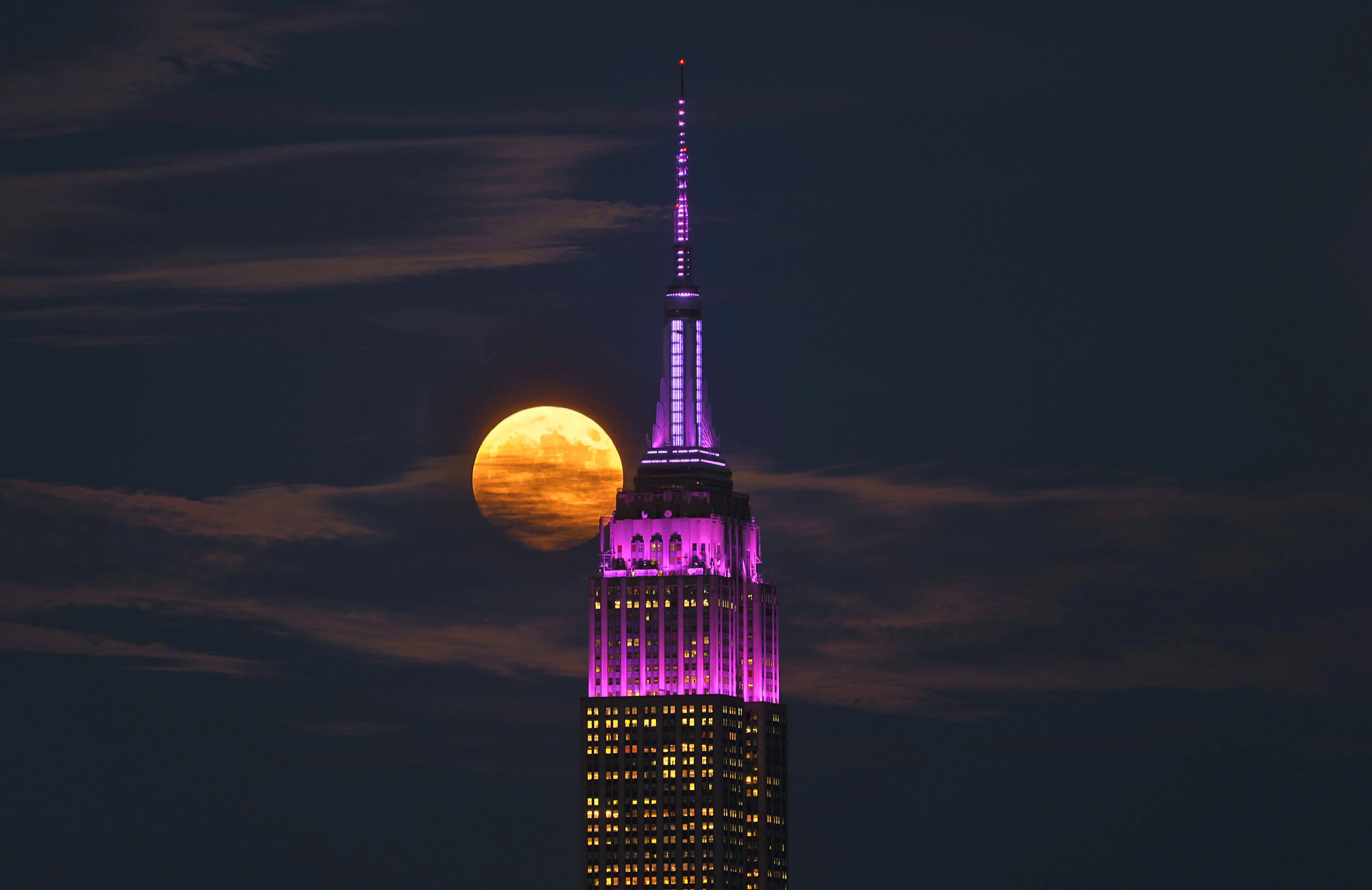 UNION CITY, NJ - SEPTEMBER 17: The full Harvest Supermoon rises behind the Empire State Building in New York City on September 17, 2024, as seen from Union City, New Jersey.  (Photo by Gary Hershorn/Getty Images)