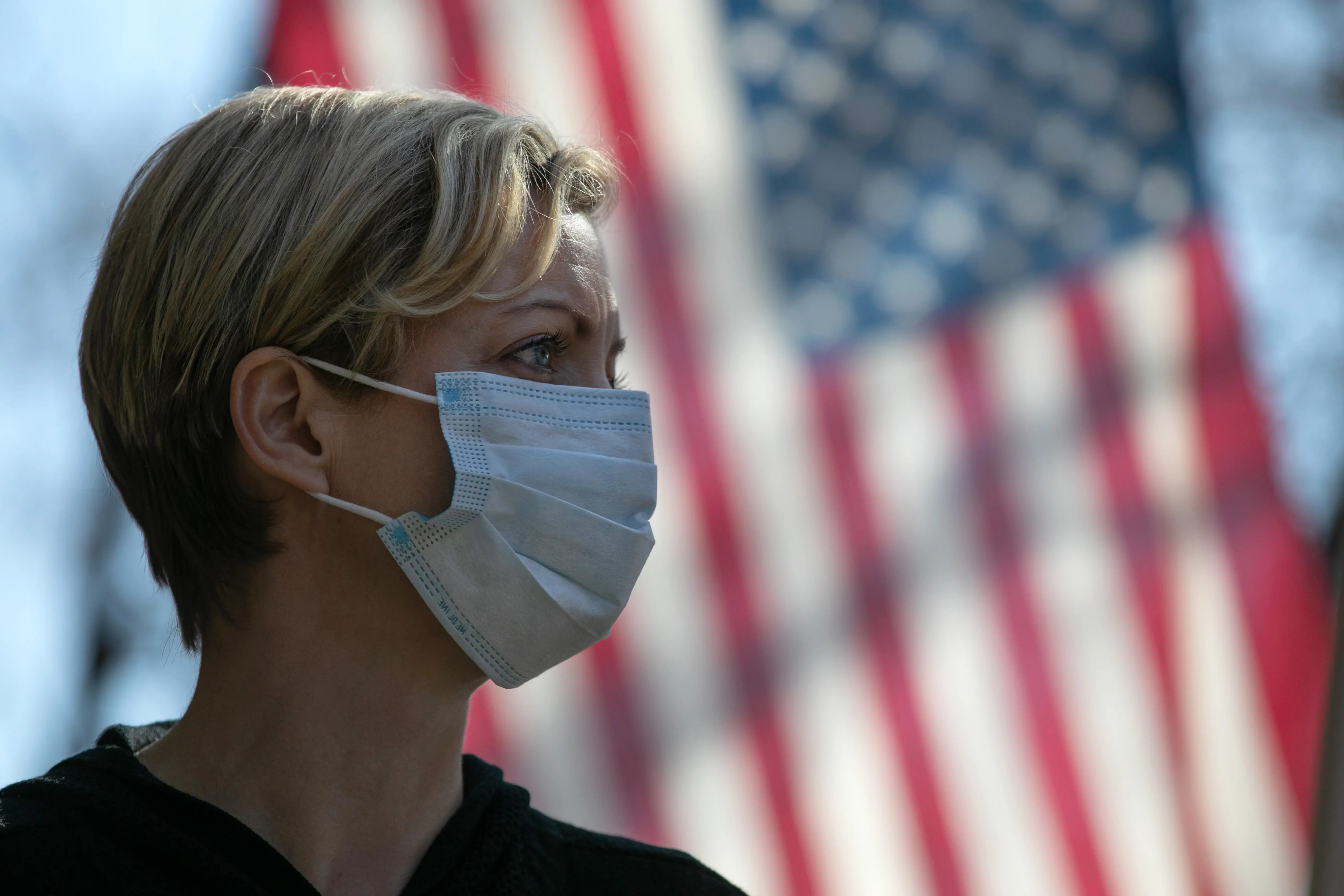 NEW ROCHELLE,  NY - MARCH 18:  Coronavirus crisis volunteer Rhiannon Navin greets local residents arriving to a food distribution center at the WestCop community center on March 18, 2020 in New Rochelle, New York. New Rochelle has been a hot spot for the COVID-19 pandemic in the U.S.  (Photo by John Moore/Getty Images)