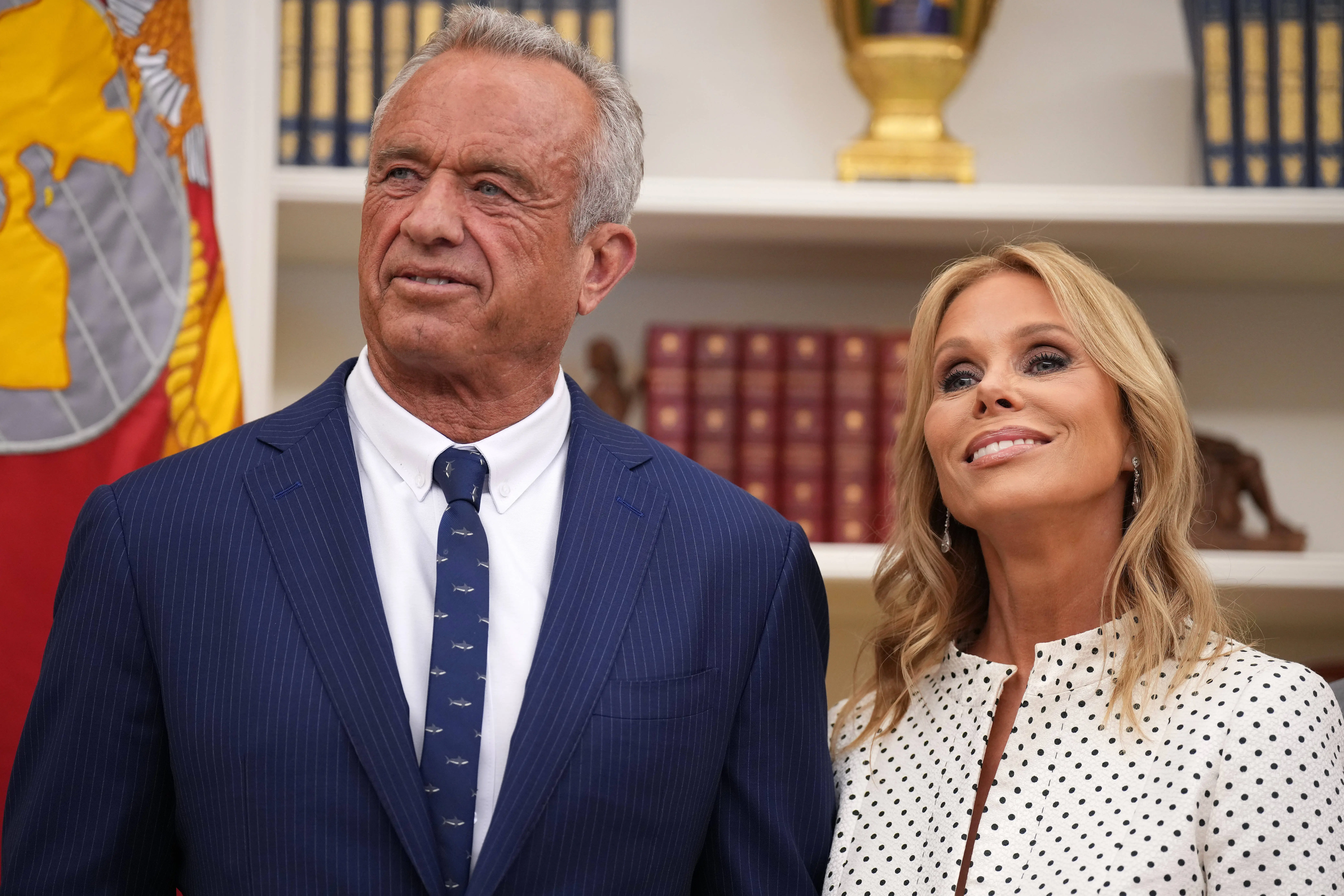 WASHINGTON, DC - FEBRUARY 13: Robert F. Kennedy Jr. and his wife Cheryl Hines listen as U.S. President Donald Trump speaks before Kennedy is sworn in as Secretary of Health and Human Services in the Oval Office at the White House on February 13, 2025 in Washington, DC. Kennedy, who faced criticism for his past comments on vaccine, was confirmed by the Senate 52 to 48. Former Senate Republican Leader Mitch McConnell (R-KY) was the only Republican to vote against him.  (Photo by Andrew Harnik/Getty Images)