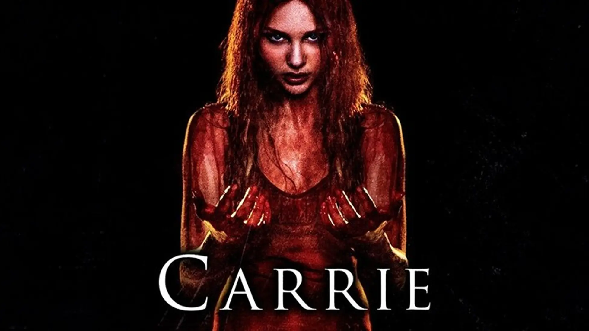 Carrie White, drenched in blood, stares ahead against a stark black background. (Image via Netflix)