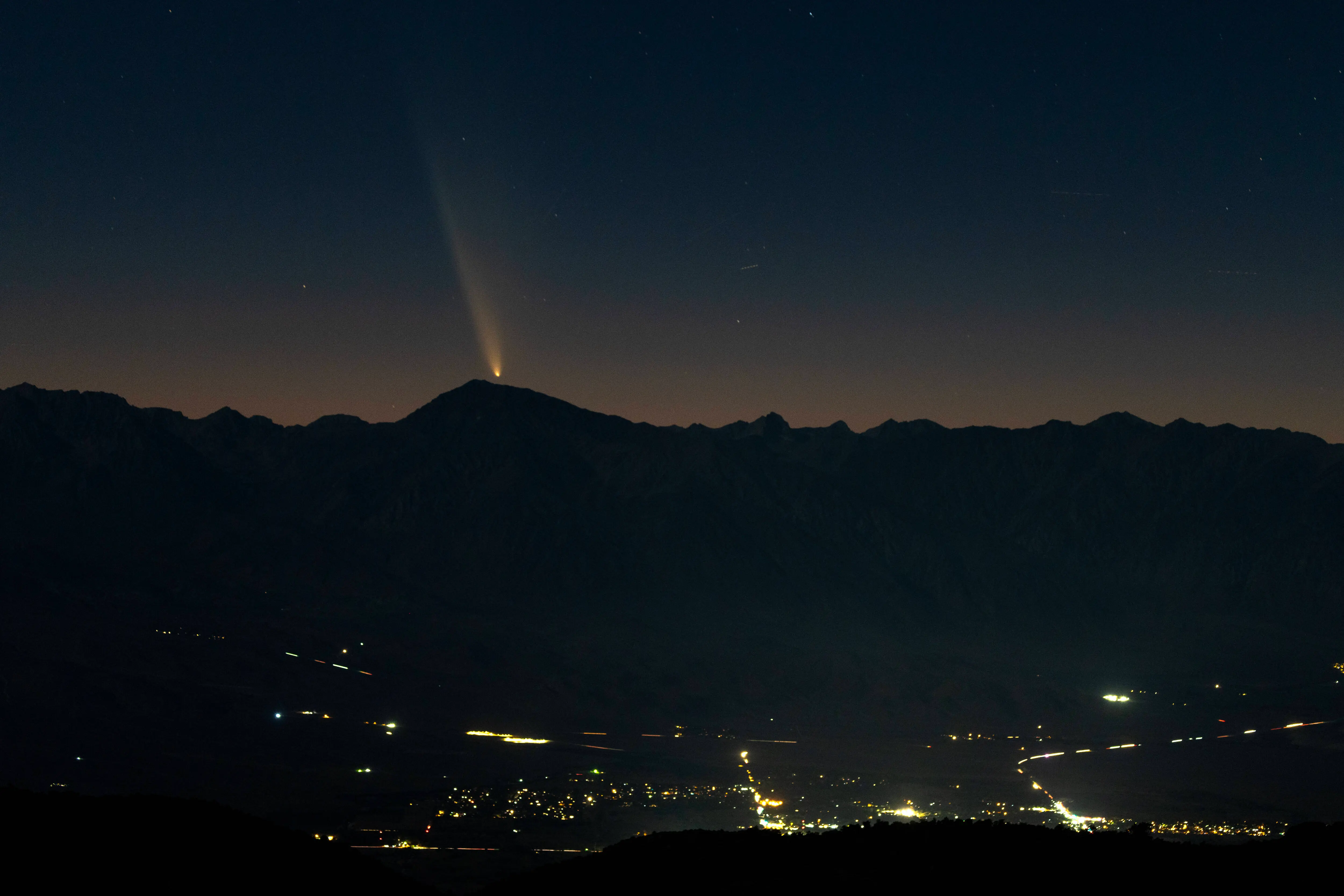 BIG PINE, CALIFORNIA - OCTOBER 12: Comet Tsuchinshan-ATLAS appears over the Eastern Sierra mountains as it transitions into the evening sky shortly after sunset, as seen from the Ancient Bristlecone Pine Forest area, on October 12, 2024 near Big Pine, California. The coma, or comet head, measures approximately 130,000 miles (209,000 kilometers) in diameter and the tail stretches out for about 18 million miles (29 million km). The comet will not return for another 80,000 years.   (Photo by David McNew/Getty Images)
