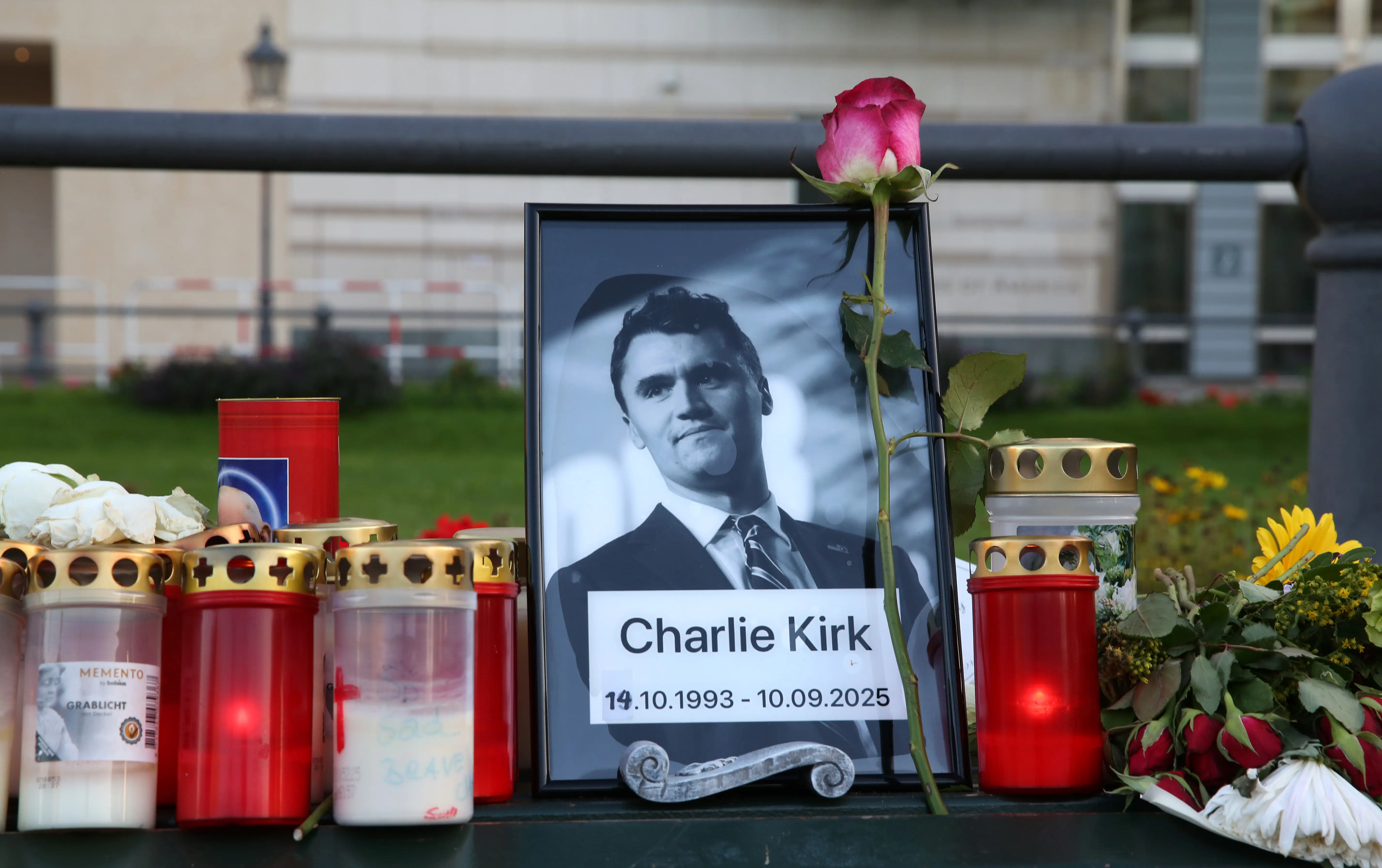BERLIN, GERMANY - SEPTEMBER 14: Flowers and candles are seen at a makeshift memorial for murdered American conservative activist Charlie Kirk outside the U.S. embassy as its flag hangs at half-staff on September 14, 2025 in Berlin, Germany. Thirty-one-year-old Kirk was shot and killed four days earlier at a discussion event at Utah Valley University just moments after he began his speech. Members of the right-wing Alternative for Germany (AfD) party held a memorial service in front of the U.S. embassy. (Photo by Adam Berry/Getty Images)