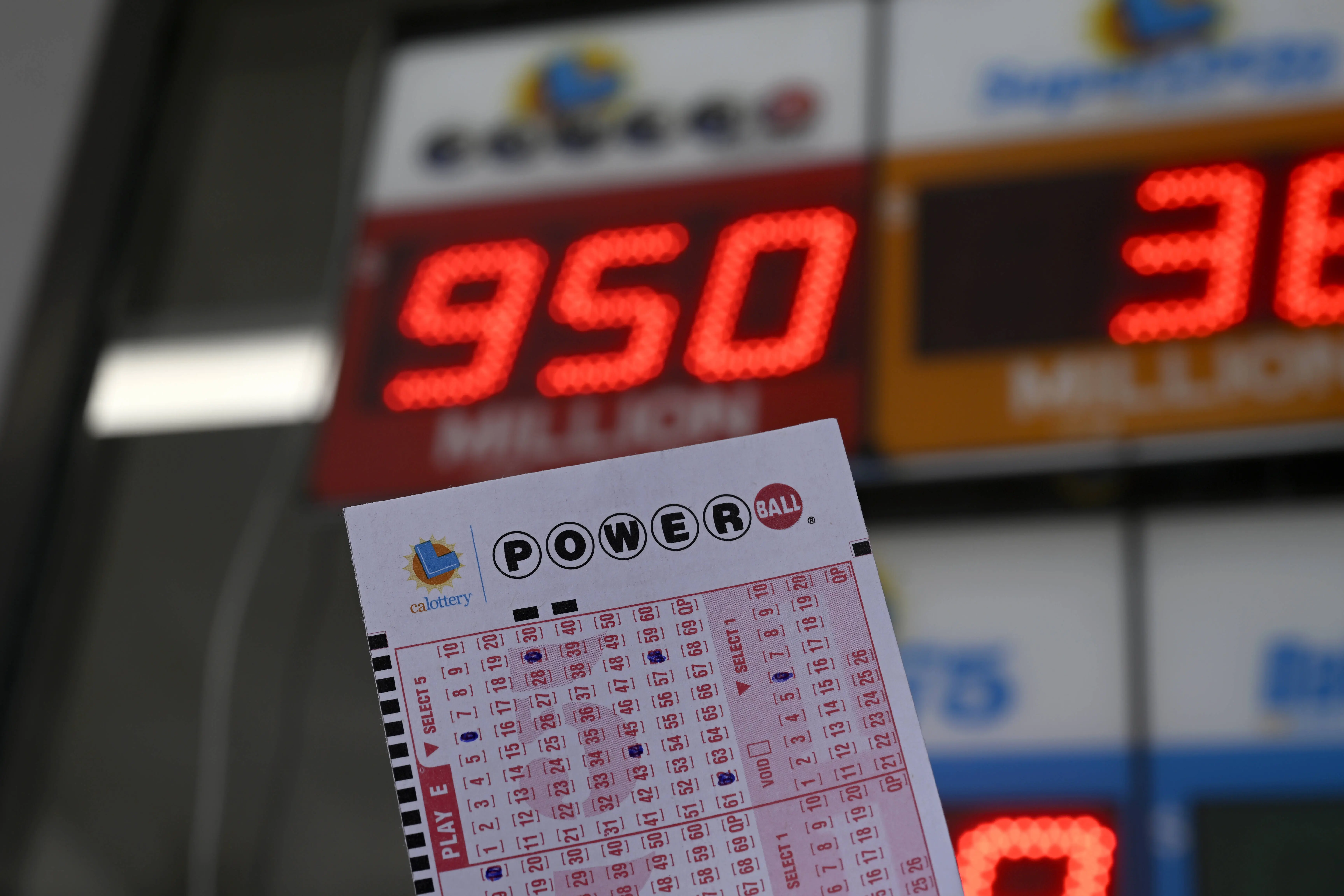 CALIFORNIA, UNITED STATES - AUGUST 28: A Powerball lottery ticket and an advertising sign are seen as U.S. Powerball jackpot grows $950 million, in Foster City, California, United States on August 28, 2025. (Photo by Tayfun Coskun /Anadolu via Getty Images)