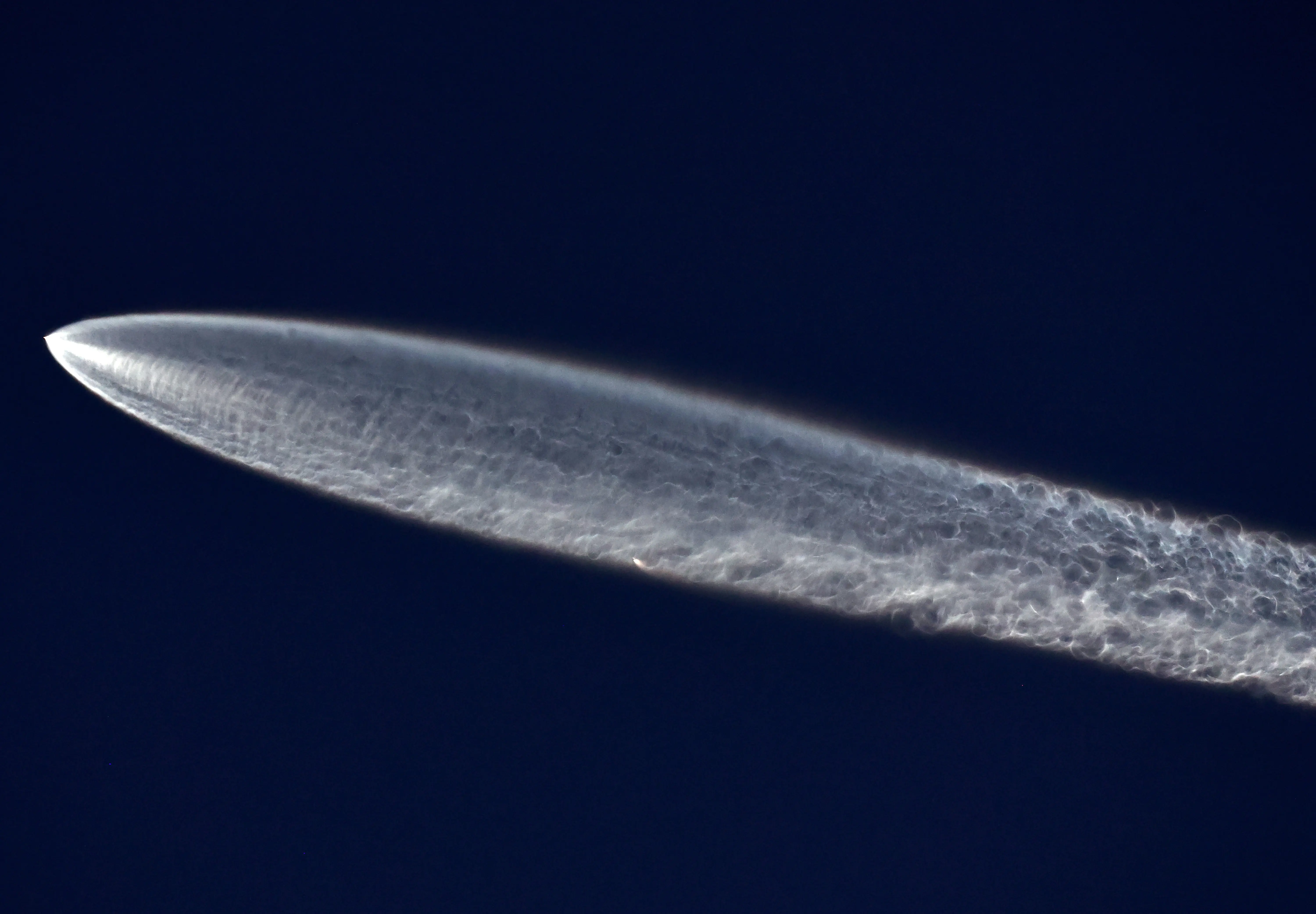 A SpaceX Falcon 9 rocket flies carrying a payload of 22 Starlink internet satellites into space after launching from Vandenberg Space Force Base on March 18, 2024 as seen from Los Angeles, California (Image via Getty)