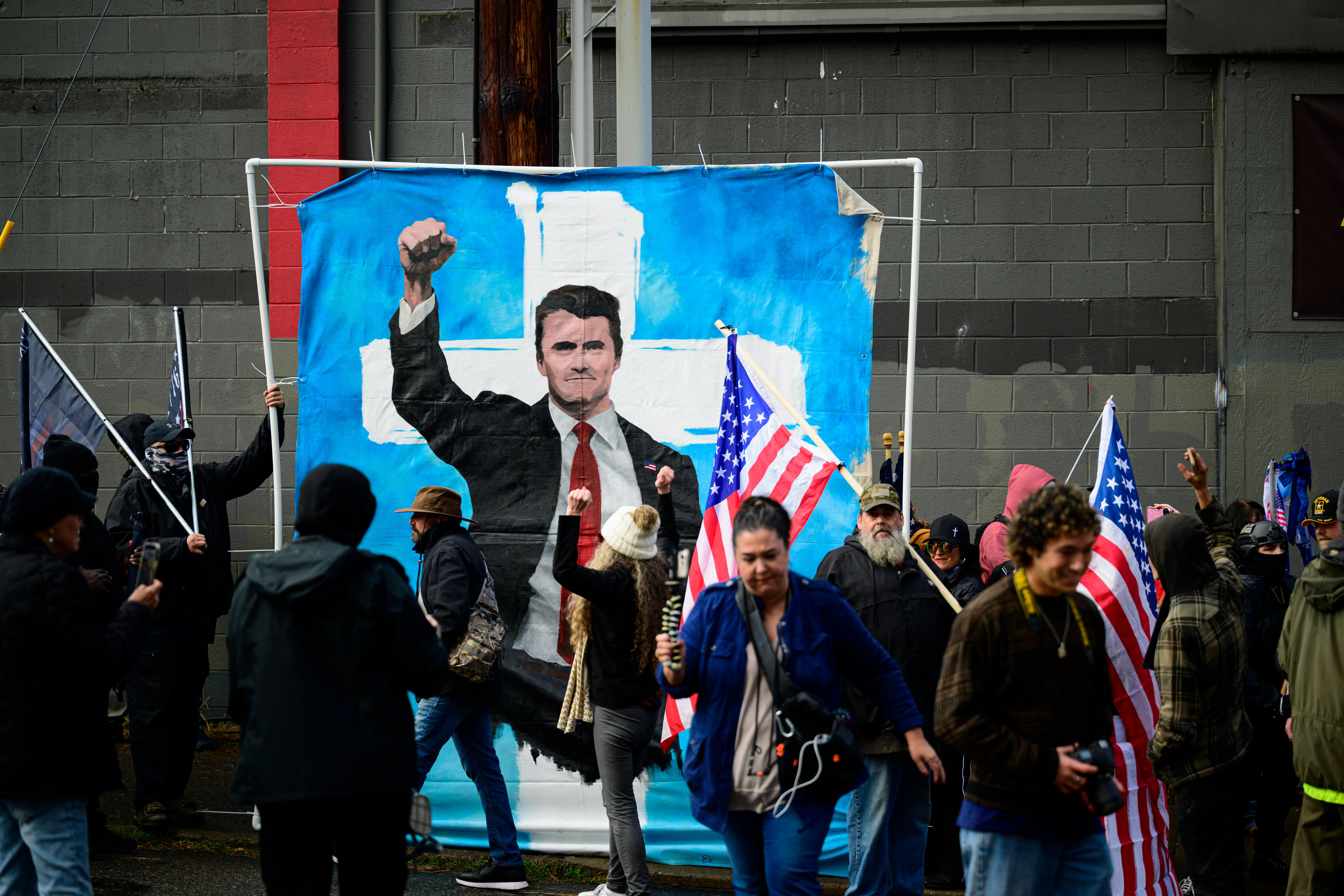 PORTLAND, OREGON - OCTOBER 12: Counter-protesters display a painting of Charlie Kirk near the U.S. Immigration and Customs Enforcement building on October 12, 2025 in Portland, Oregon. An Instagram post from the WorldNakedBikeRidePortland account stated - "The emergency WNBR Portland is in response to the militarization of our peaceful city. Right now peaceful protesters are being brutalized as they do their best for our neighbors and cousins who are being kidnapped." (Photo by Mathieu Lewis-Rolland/Getty Images)