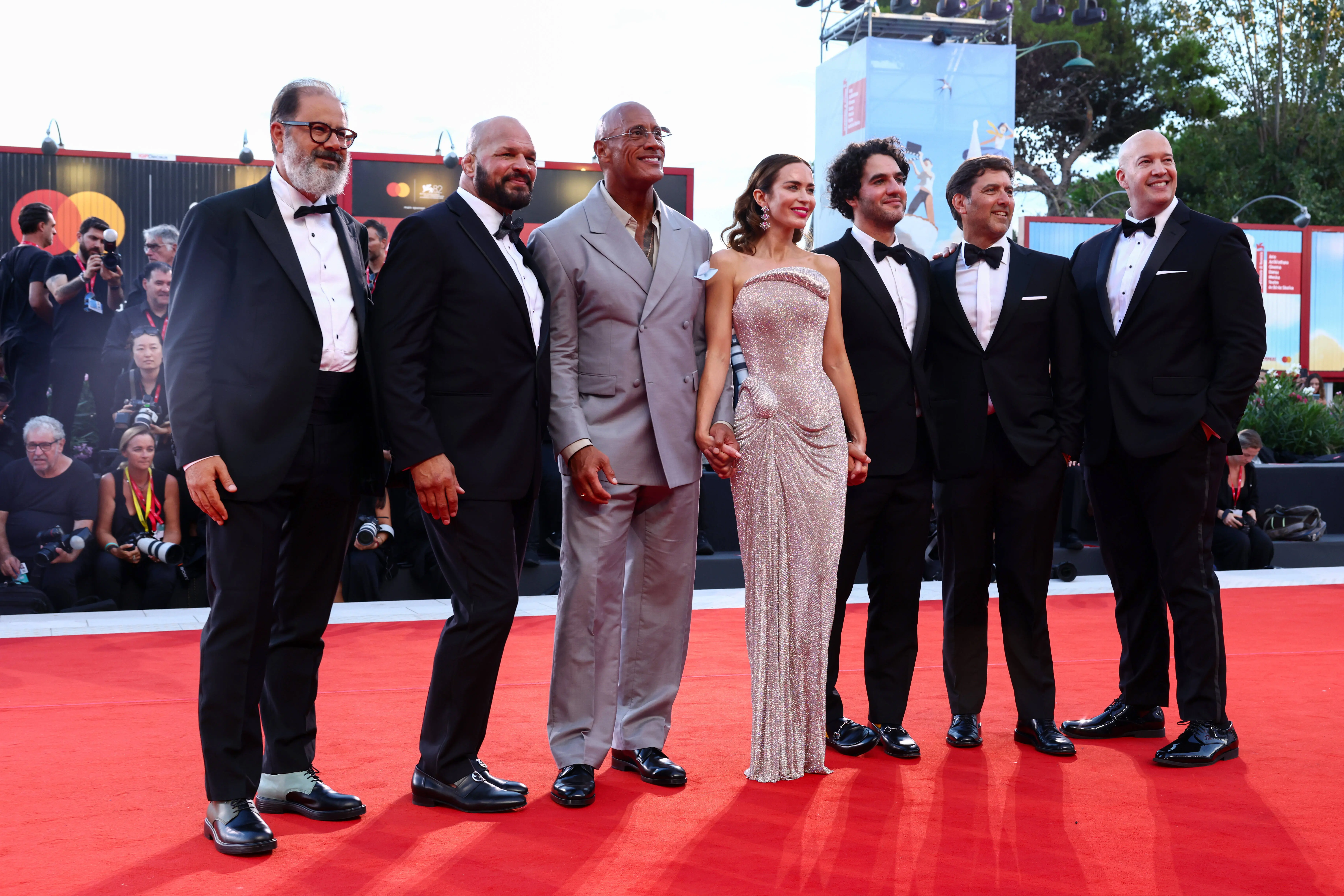 VENICE, ITALY - SEPTEMBER 01: (L-R) Andrea Romeo, Mark Kerr, Dwayne Johnson, Emily Blunt, Benny Safdie, David Koplan and Hiram Garcia attend "The Smashing Machine" red carpet during the 82nd Venice International Film Festival on September 01, 2025 in Venice, Italy. (Photo by Aldara Zarraoa/Getty Images)