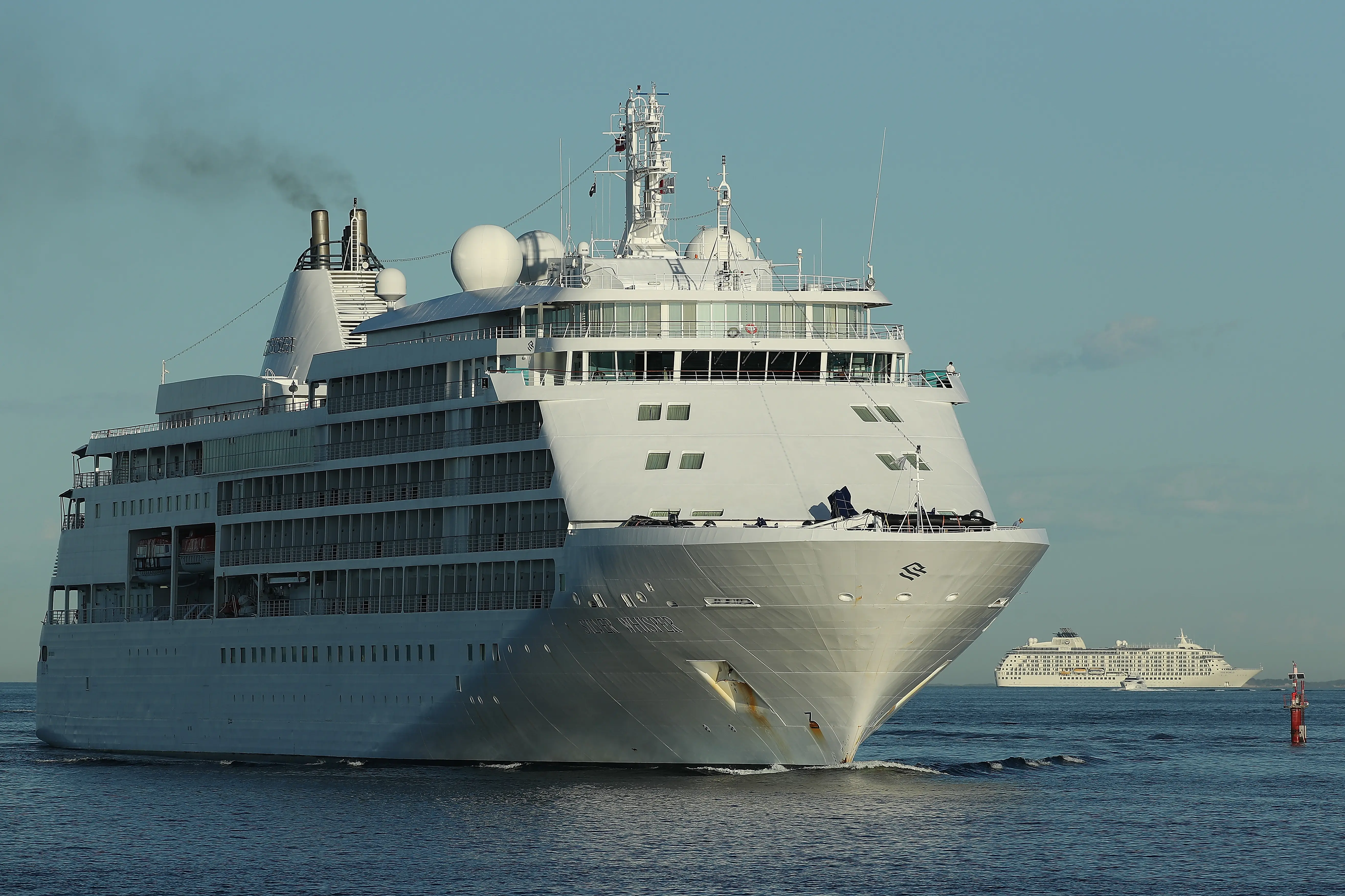 FREMANTLE, AUSTRALIA - MARCH 26: The cruise ship Silver Whisper heads into Fremantle Harbour to refuel as The World is anchored between Fremantle and Rottnest Island on March 26, 2020 in Fremantle, Australia. West Australian Premier Mark McGowan has requested the Australian Navy direct the Artania cruise ship moored off the Fremantle coast to leave Australian waters following confirmation seven passengers had tested positive for COVID-19. WA health officials boarded the Artania on Wednesday testing and assessing people, but as no Australian passengers on board the state government does not want to allow anyone to disembark. The MSC Magnifica - which refuelled in Fremantle on Tuesday - has also returned after being denied access to ports in Dubai but the WA State Government has instructed the ship to return to its home port. The Vasco de Gama is due to dock in Fremantle on Friday, with all Australian passengers allowed to disembark and transfer to Rottnest Island which has been set up as a quarantine camp. Australia now has 2676 confirmed cases of COVID-19, and the death toll stands at 11.  (Photo by Paul Kane/Getty Images)