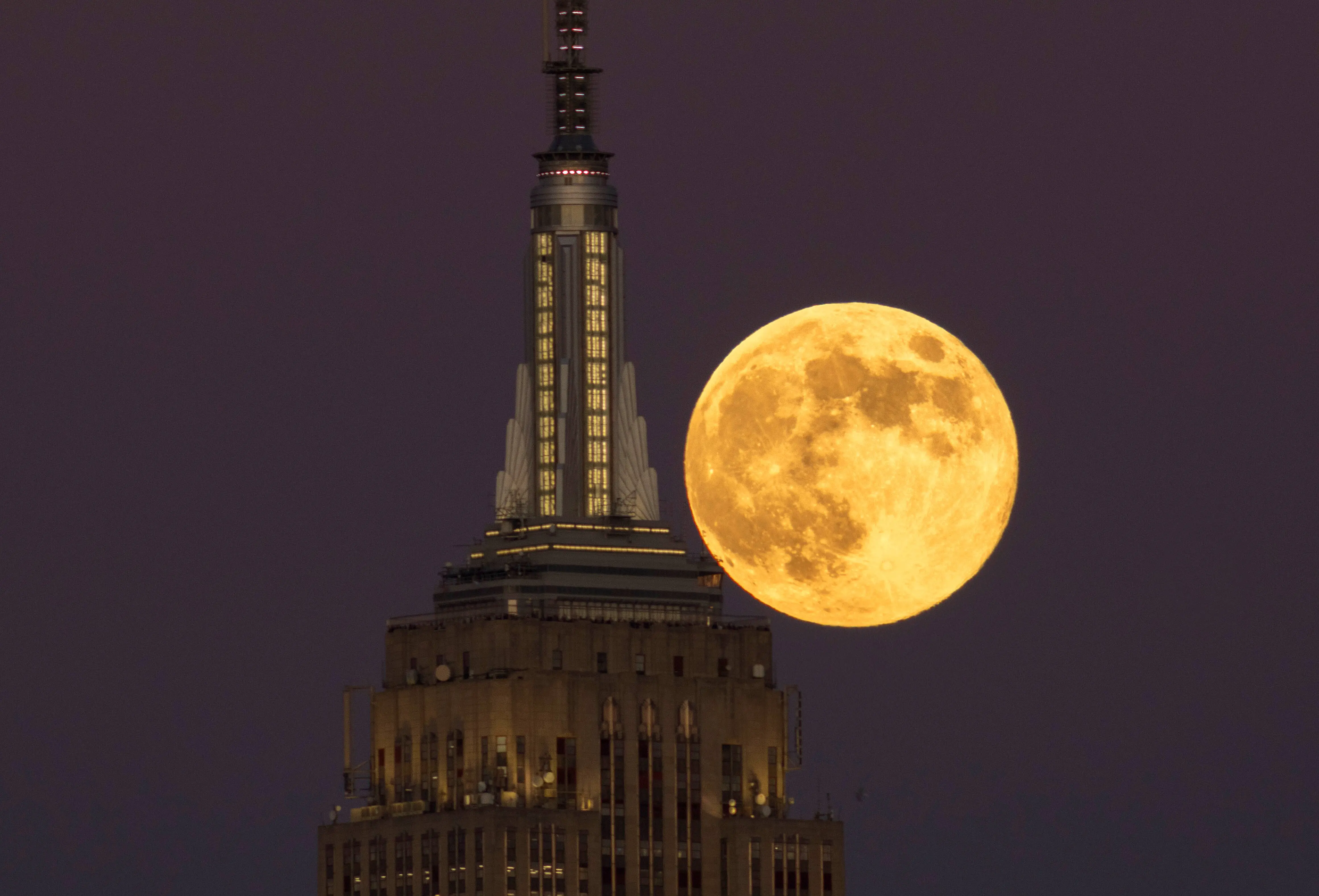 JERSEY CITY, NJ - NOVEMBER 15: The full Beaver Supermoon rises behind the Empire State Building in New York City as the sun sets on November 15, 2024, as seen from Jersey City, New Jersey.  (Photo by Gary Hershorn/Getty Images)