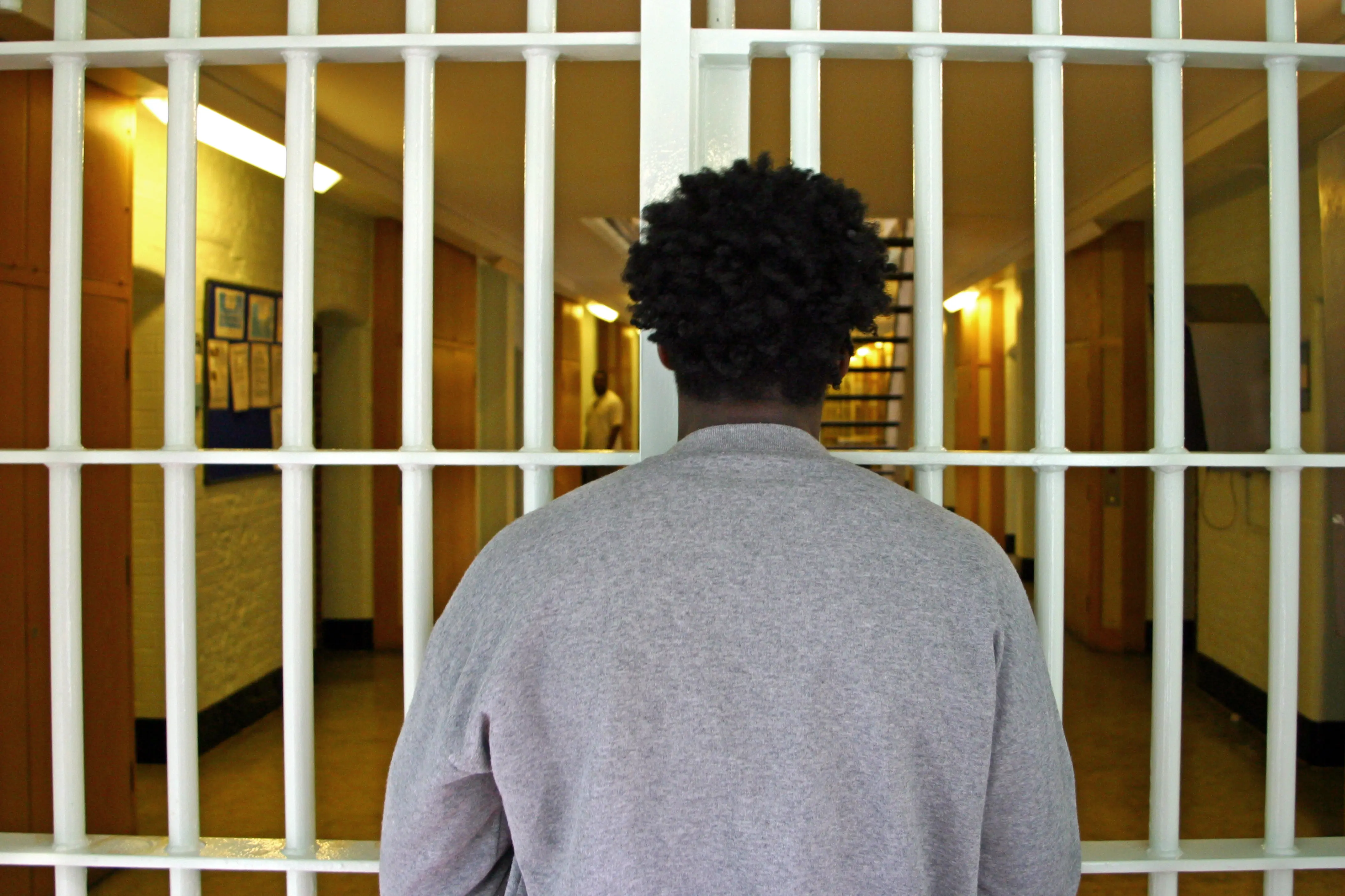 A young black male prisoner waits at a security partition gate in the D wing of Wandsworth prison. HMP Wandsworth in South West London was built in 1851 and is one of the largest prisons in Western Europe. It has a capacity of 1456 prisoners. (Photo by Andrew Aitchison/In Pictures Ltd./Corbis via Getty Images)