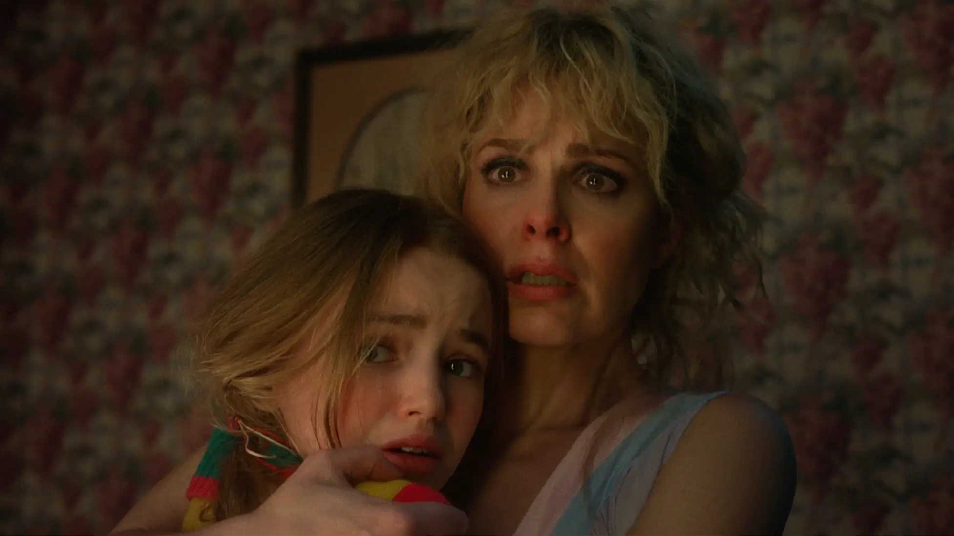 Karen Wheeler and Holly Wheeler cling to each other during the Wheeler house attack in Stranger Things 5. Image via Netflix