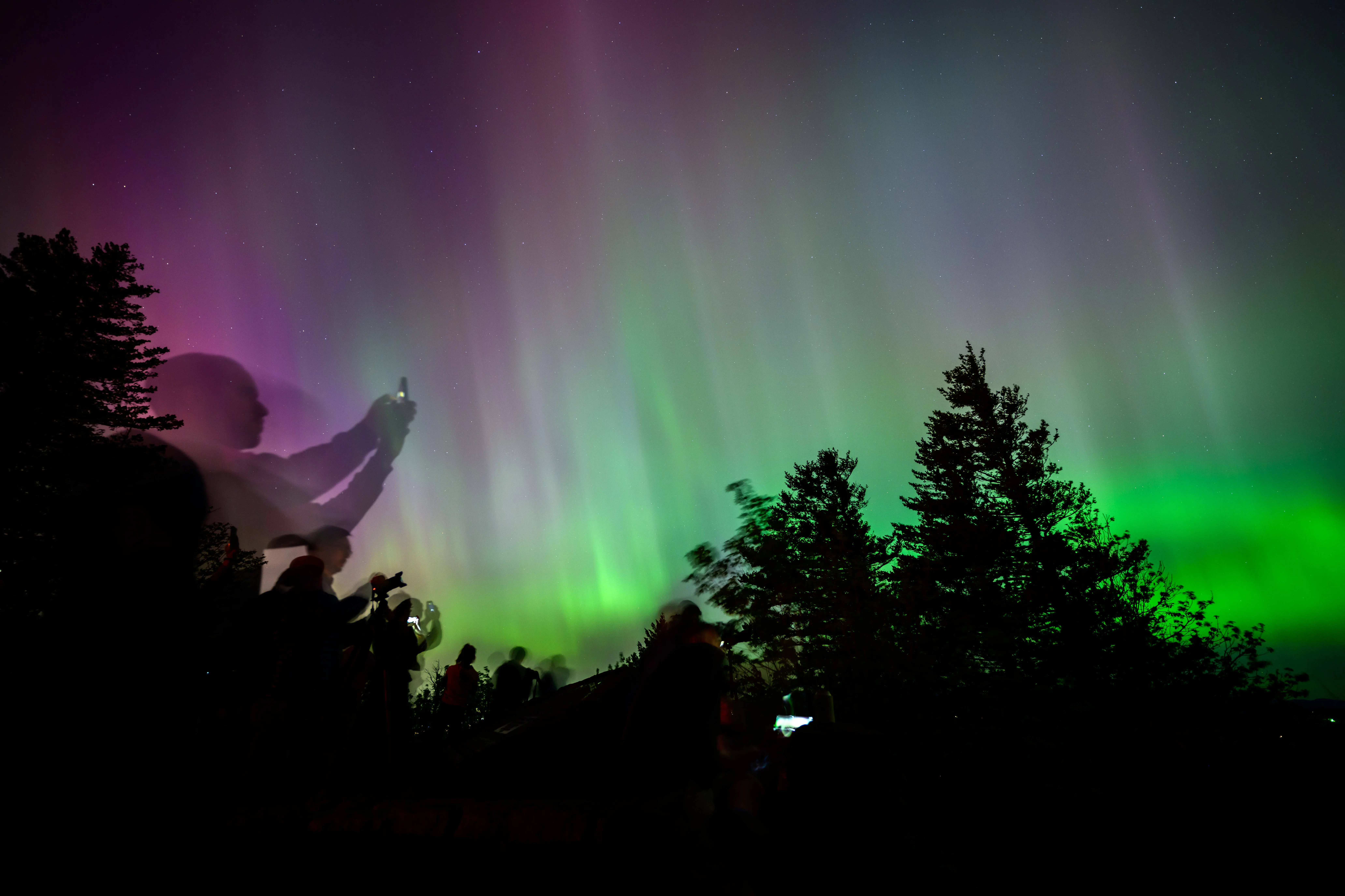 LATOURELL, OREGON - MAY 11: Onlookers gaze upon and photograph the Northern Lights at Chanticleer Point Lookout on the Columbia River Gorge in the early morning hours of May 11, 2024 in Latourell, Oregon. Places as far south as Alabama and parts of Northern California were expected to see the aurora borealis, also known as the northern lights from a powerful geomagnetic storm that reached Earth. (Photo by Mathieu Lewis-Rolland/Getty Images)