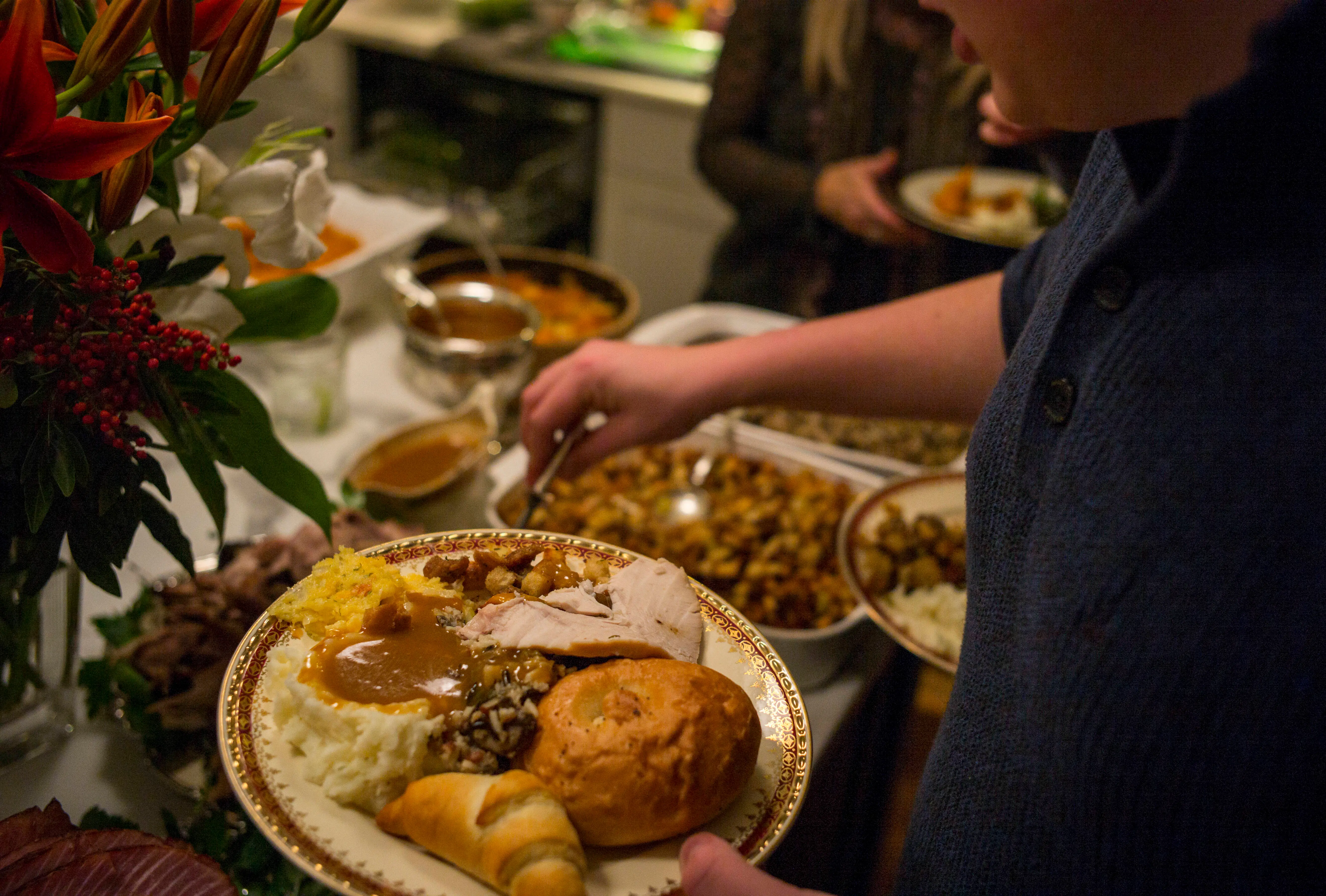 Unidentified diners serve themselves food at a traditional Thanksgiving Day family gathering in Bloomfield Hills, Michigan on November 26, 2015. (Photo by Robert Nickelsberg/Getty Images)