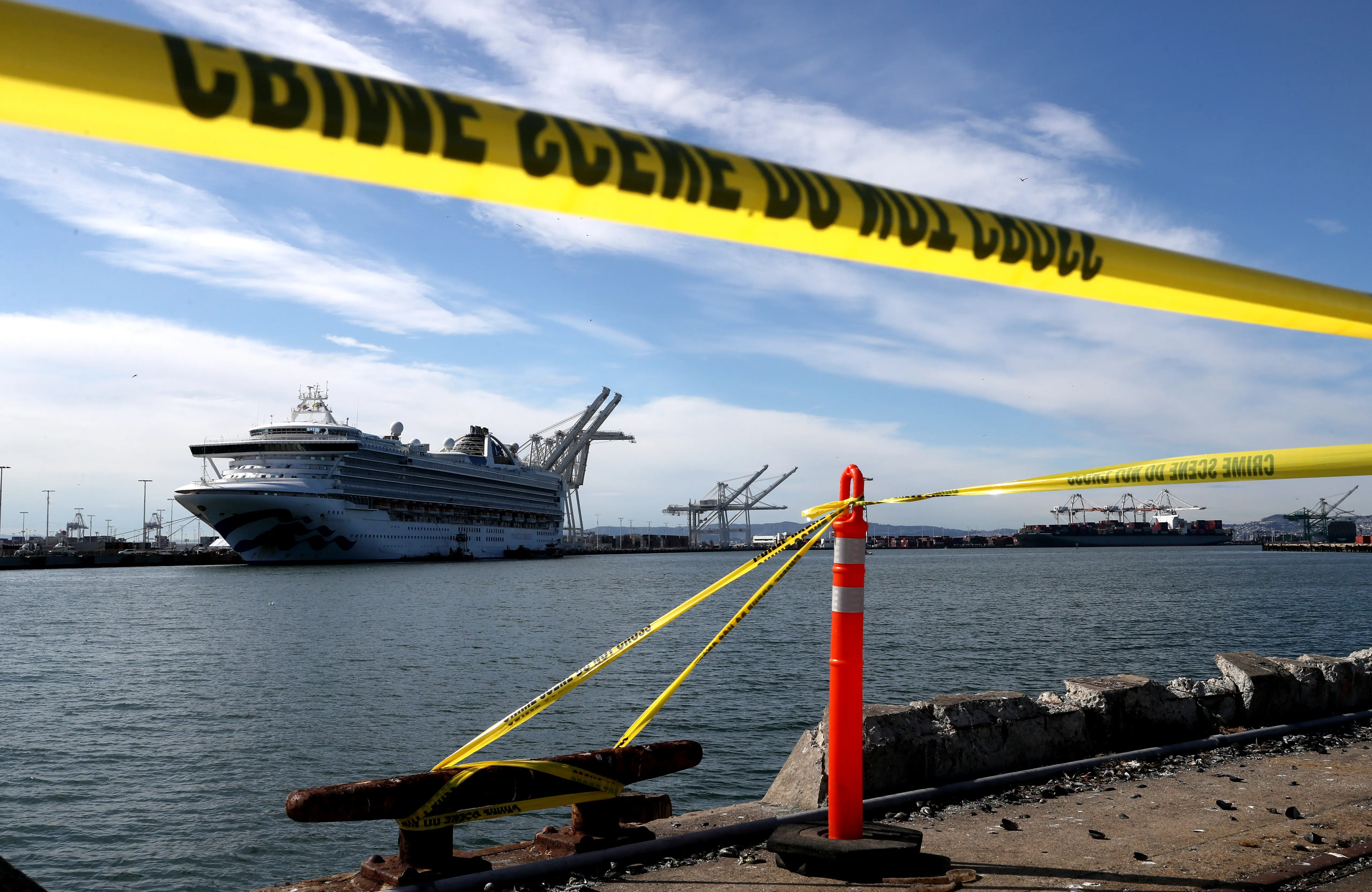 OAKLAND, CALIFORNIA - MARCH 10: Crime scene tape marks off the area where members of the media are staging near the Princess Cruises Grand Princess cruise ship as it sits docked in the Port of Oakland on March 10, 2020 in Oakland, California. Passengers are slowly disembarking from the Princess Cruises Grand Princess a day after it docked at the Port of Oakland. The ship was held off the coast of California after 21 people on board tested tested positive for COVID-19 also known as the Coronavirus. (Photo by Justin Sullivan/Getty Images)