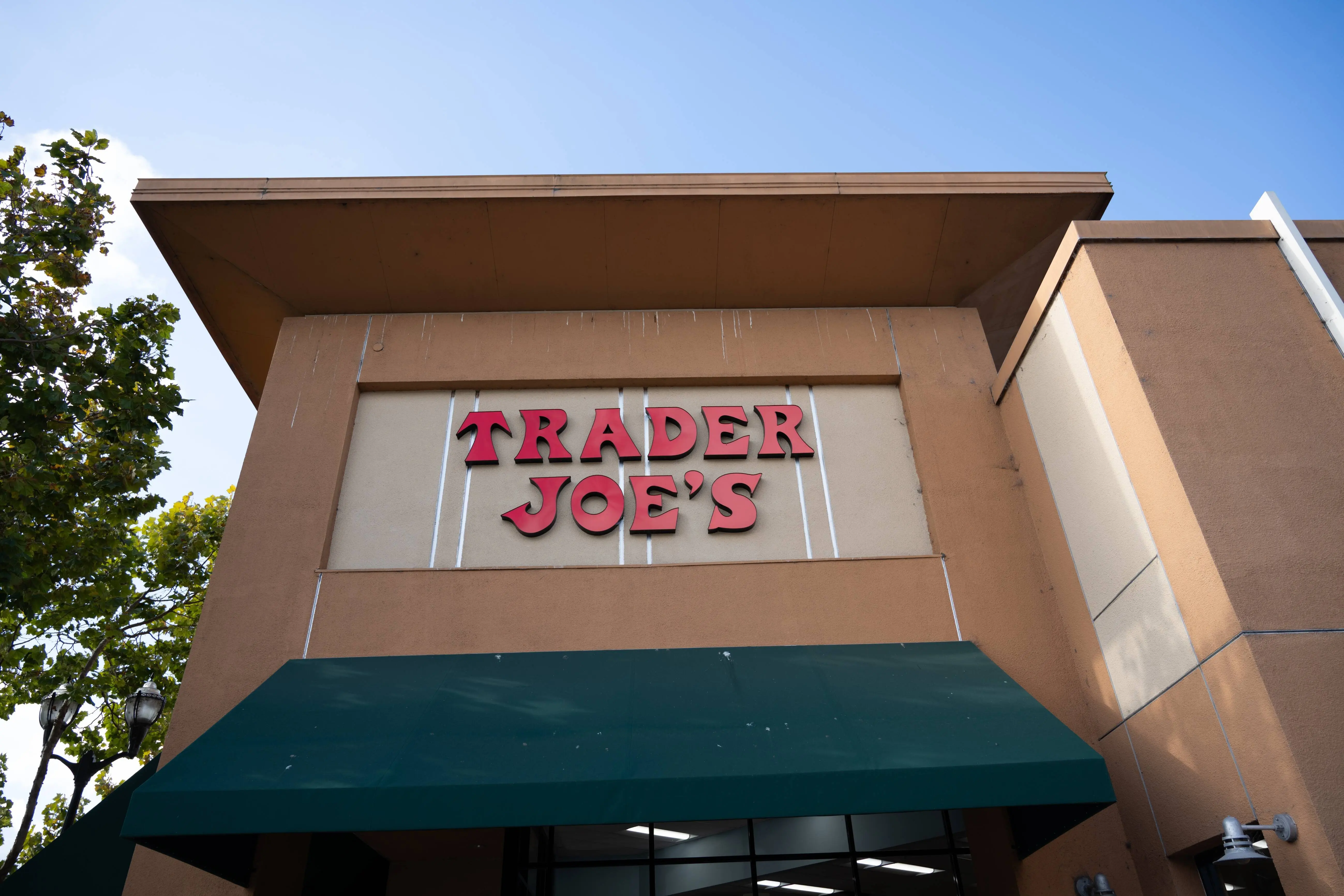 Trader Joe's supermarket exterior with red sign and green awning on a clear day, South San Francisco, California, October 16, 2025. (Photo by Smith Collection/Gado/Getty Images)