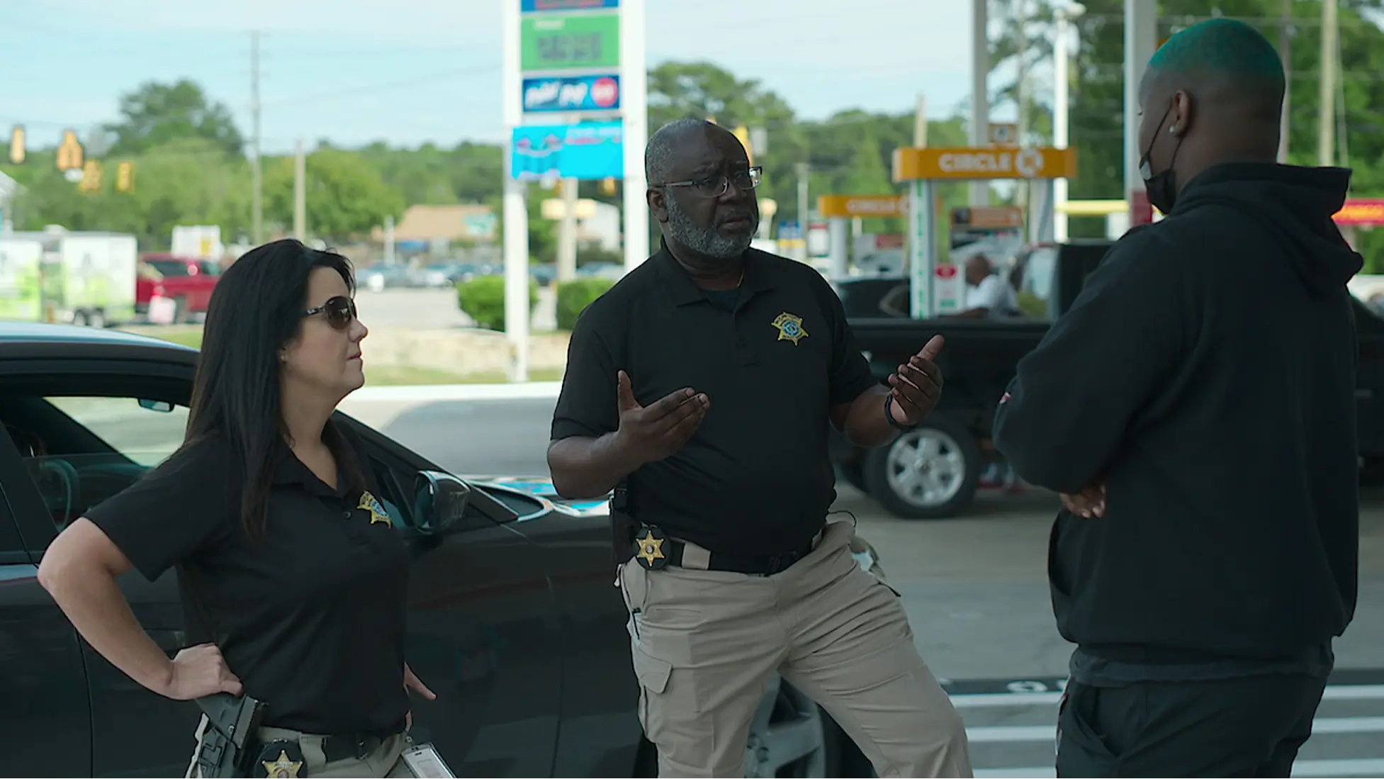 Missing: Dead or Alive? Season 2 : Richland County Sheriff’s Department investigators speak with a community member during a gas-station canvass in Columbia, South Carolina. Image via Netflix.
