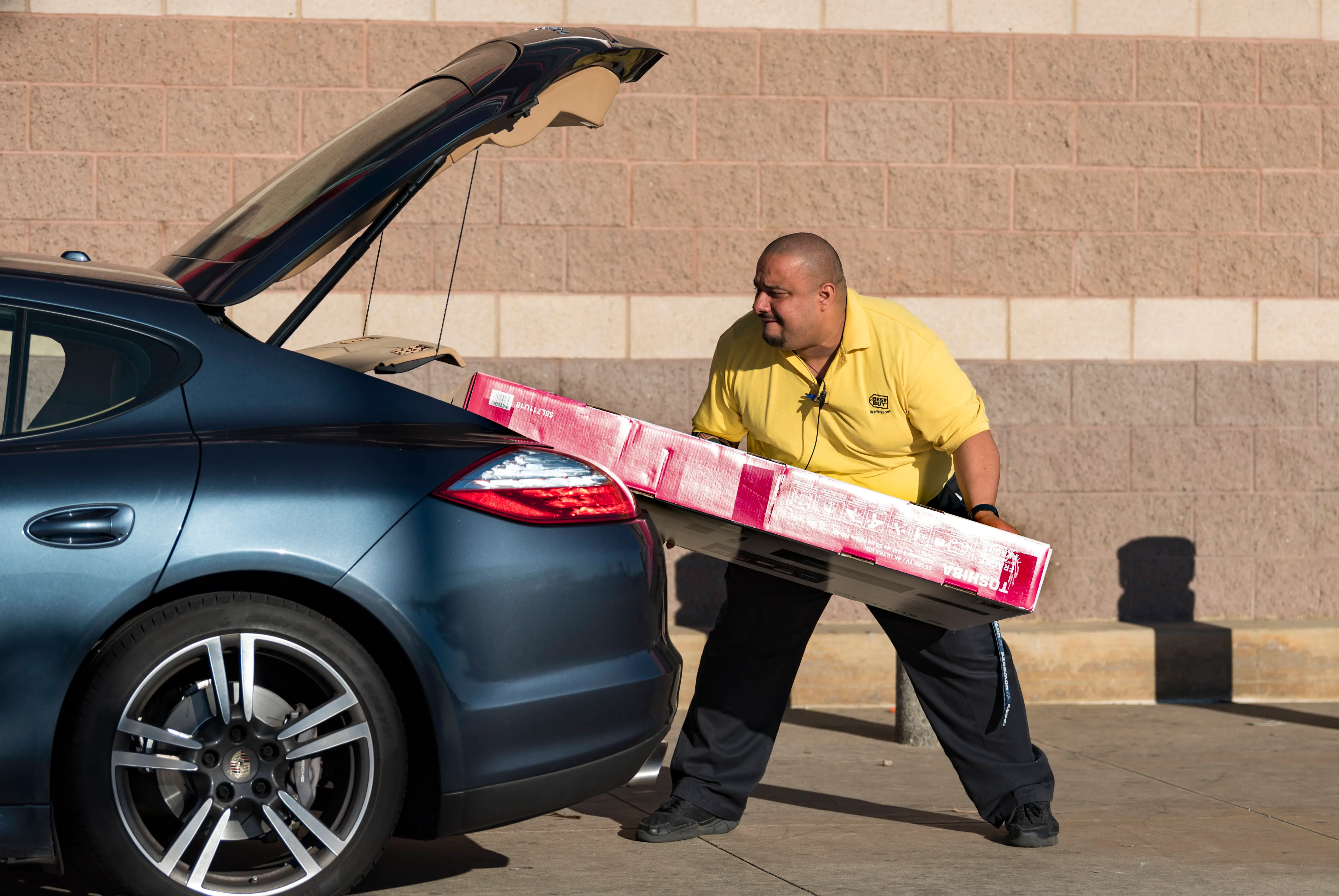 A Best Buy employee loads a TV into a customers car on Black Friday in Los Angeles, California on November 24, 2017. Black Friday occurs the day after Thanksgiving and kicks off the holiday shopping season, as retailers lure shoppers with reduced prices. (Photo by Ronen Tivony/NurPhoto via Getty Images)