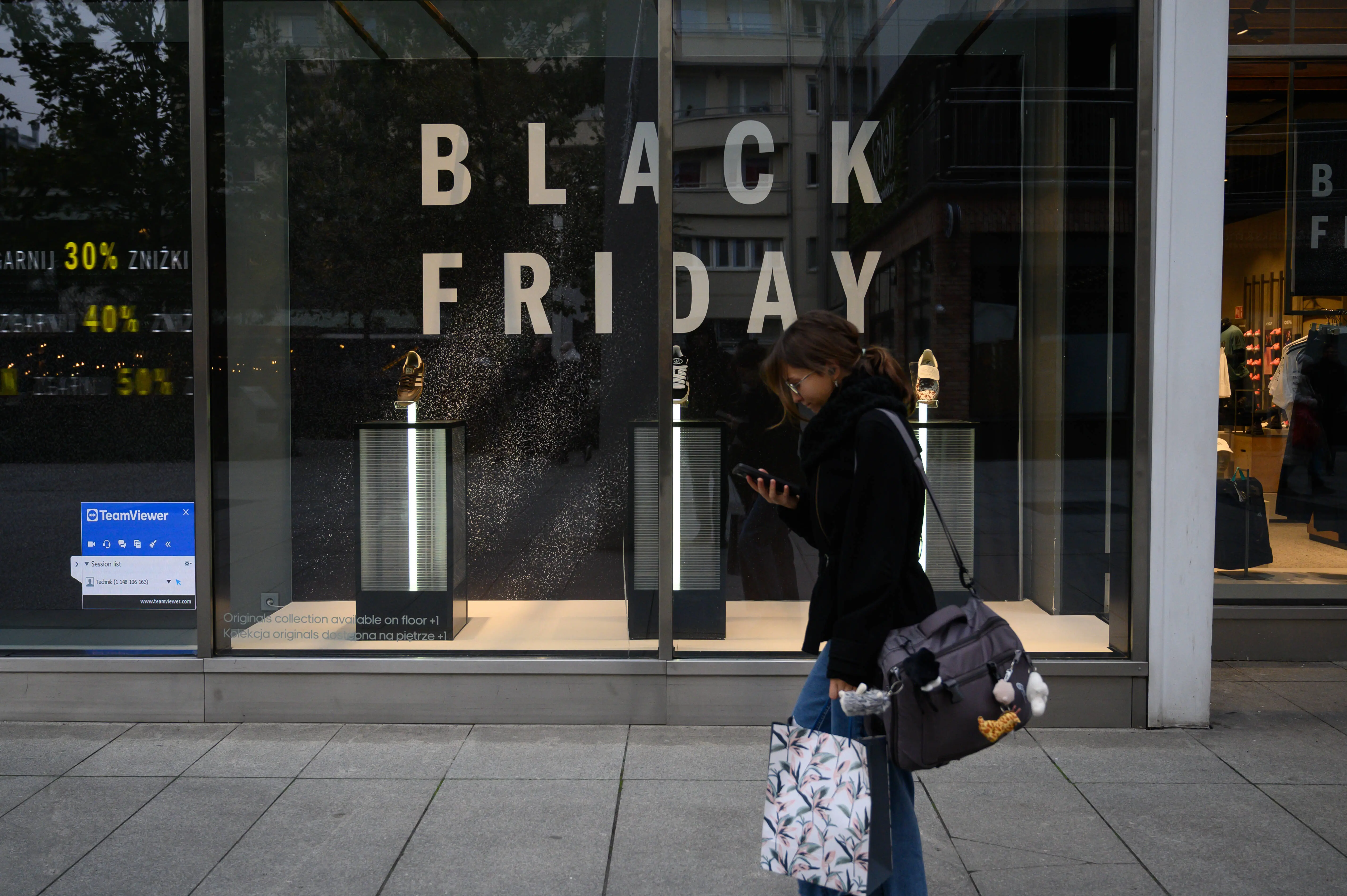 A person walks past a Black Friday advertisement displayed on a shop window in Warsaw, Poland, on November 21, 2025. (Photo by Aleksander Kalka/NurPhoto via Getty Images)