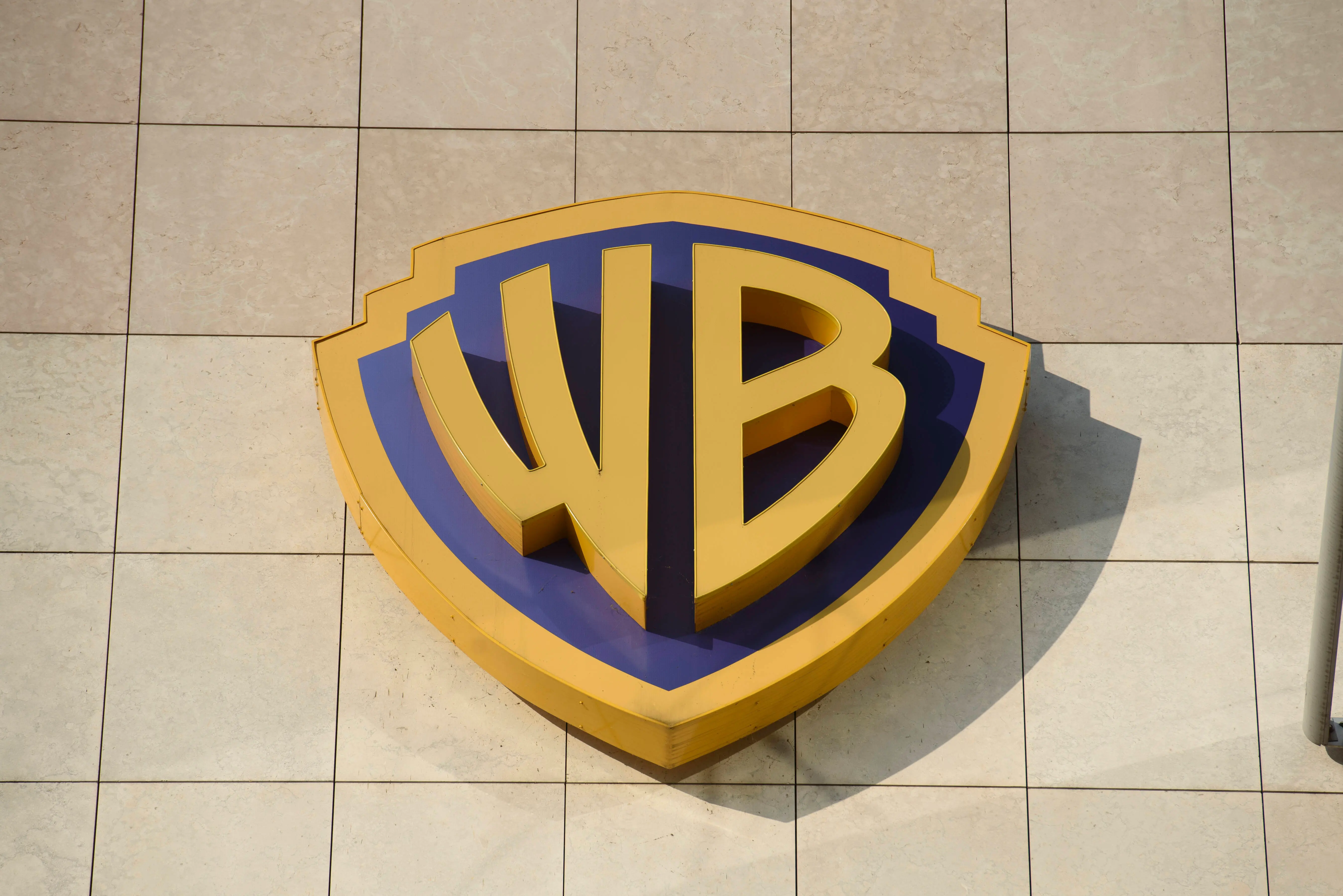 A Warner Bros (Discovery) sign is being pictured at the TVN broadcaster headquarters in Warsaw, Poland, on August 6, 2024. Warner Bros Discovery is looking to offload smaller assets in a bid to avoid a breakup of the company. (Photo by Aleksander Kalka/NurPhoto via Getty Images)