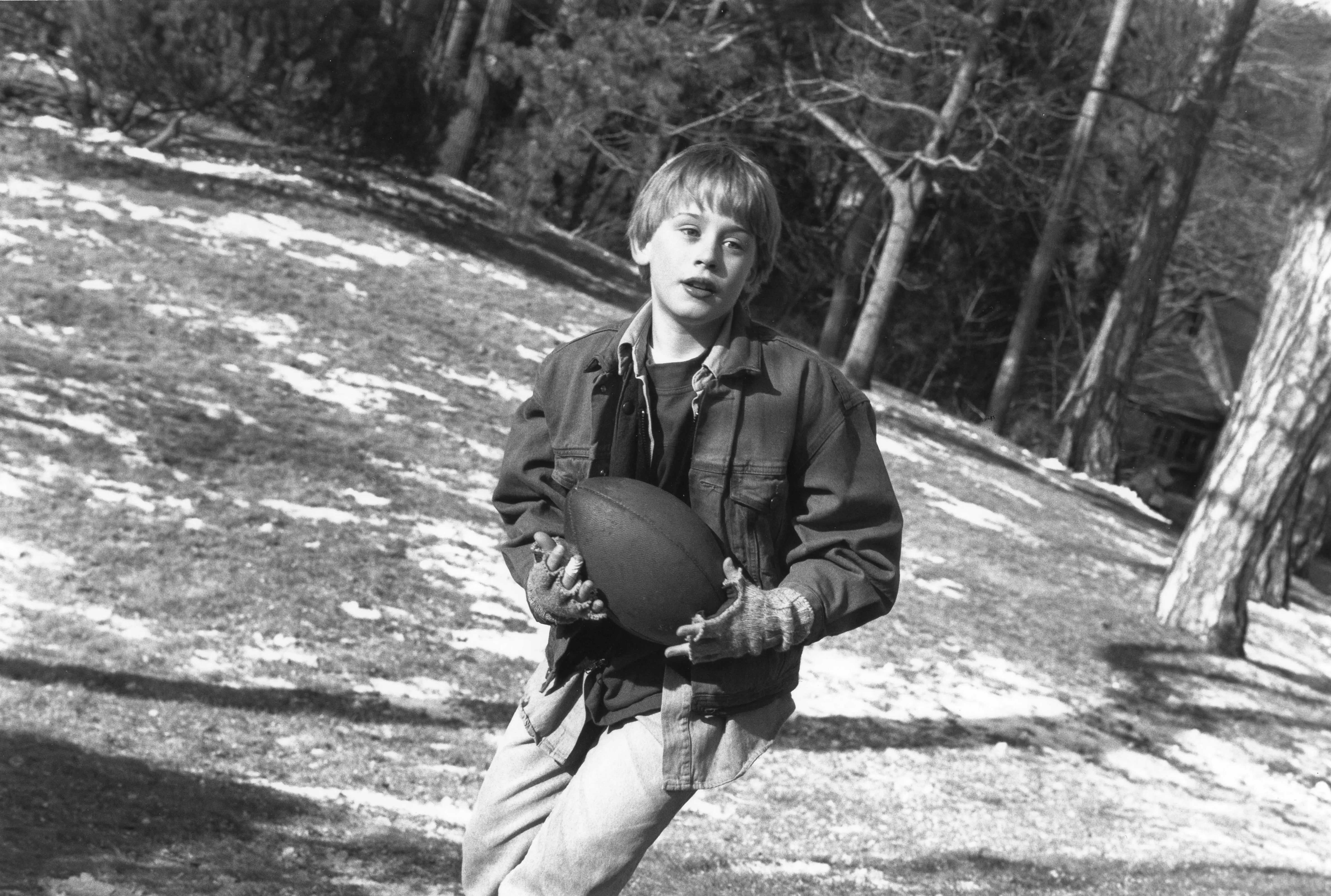 Macaulay Culkin plays football as Henry Evans during the filming of 'The Good Son' (directed by Joseph Ruben) in Manchester by the Sea, Massachusetts, in 1992. (Photo by Mikki Ansin/Getty Images)
