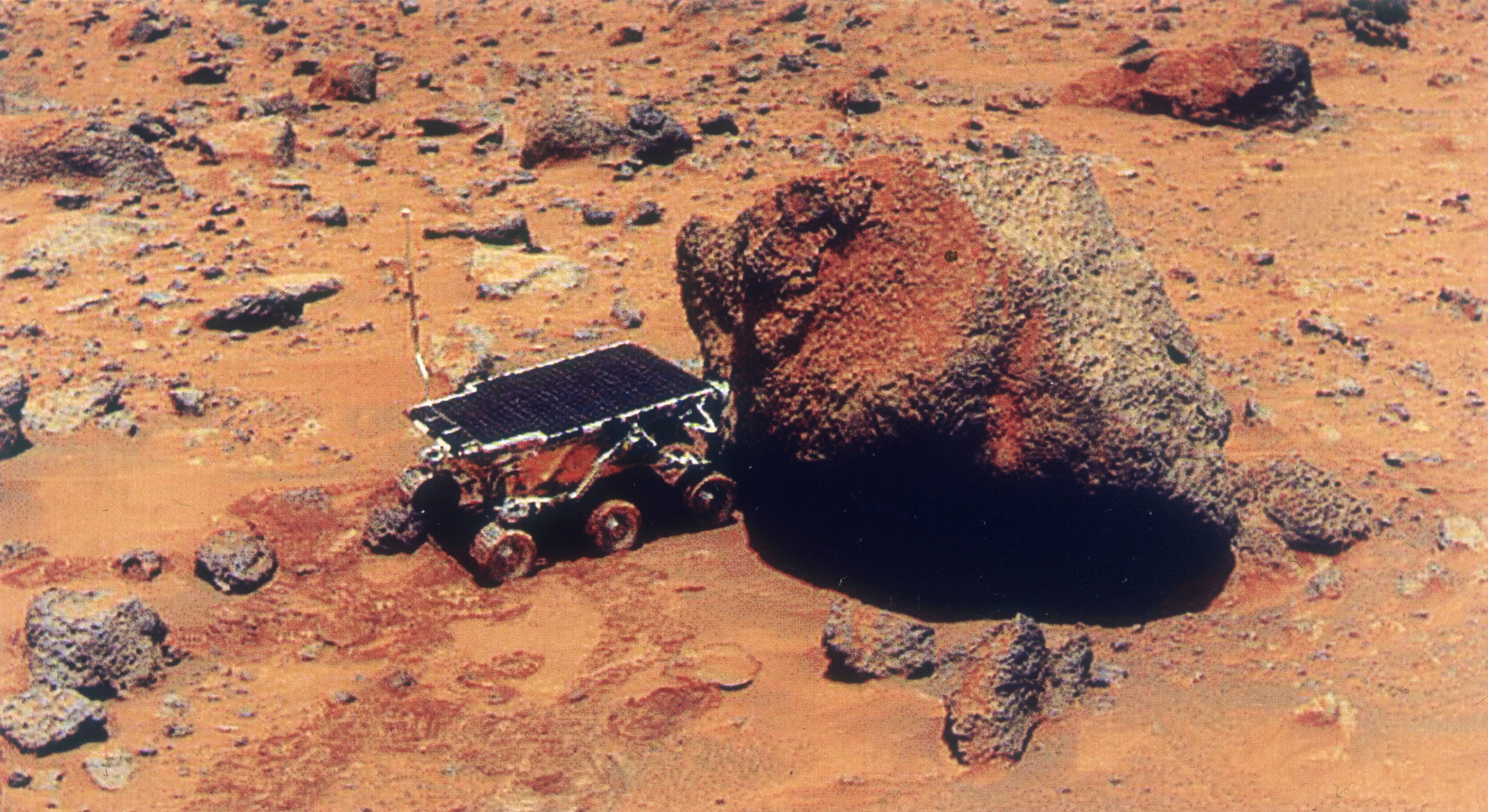 The Sojourner Rover uses its Alpha Proton X-Ray Spectrometer (APXS) to analyse the Yogi Rock on the surface of Mars, during the Mars Pathfinder exploratory mission, July 1997 (Image via Getty)