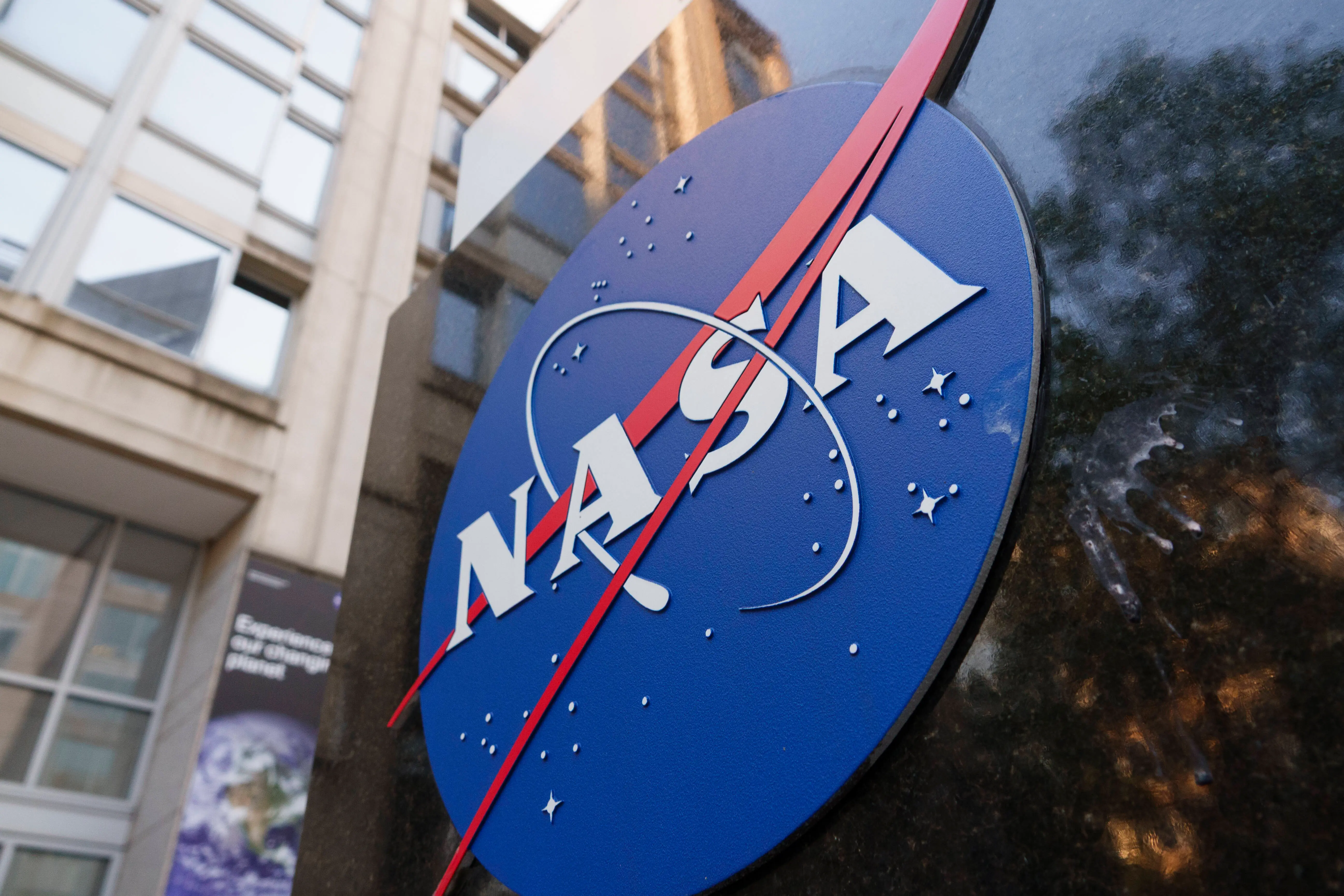 A NASA logo is displayed at the entrance to the Mary W. Jackson NASA Headquarters building (Image via Getty)