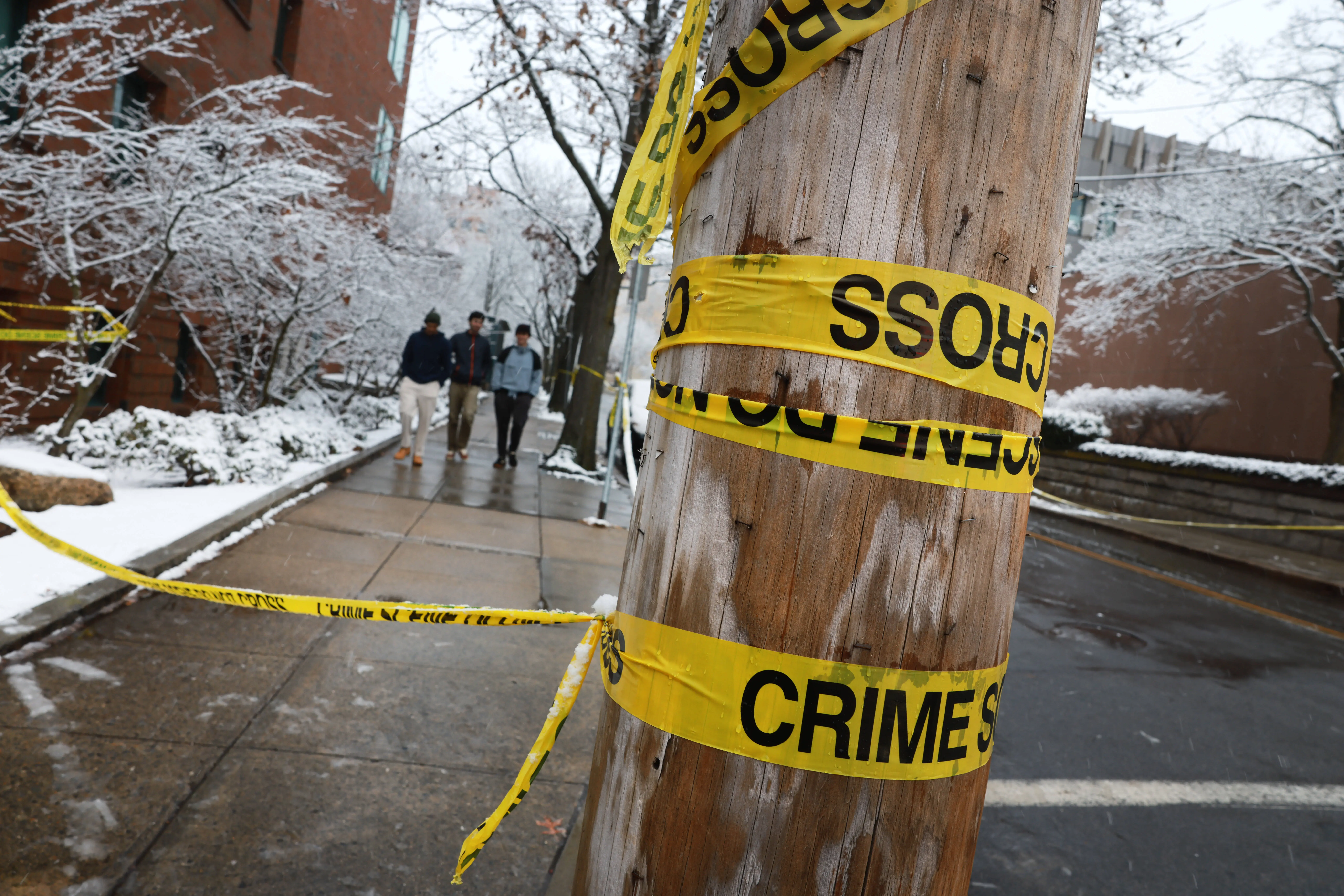 PROVIDENCE, RHODE ISLAND - DECEMBER 14: Students walk through the campus at Brown University following a mass shooting yesterday that left at least two people dead and nine others injured on December 14, 2025 in Providence, Rhode Island. A suspect in the shooting was detained overnight at a hotel in a nearby community following a manhunt across the prestigious university and the greater Providence area. The shooting took place around 4 p.m. on Saturday as students were preparing for exams and the holiday break. (Photo by Spencer Platt/Getty Images)