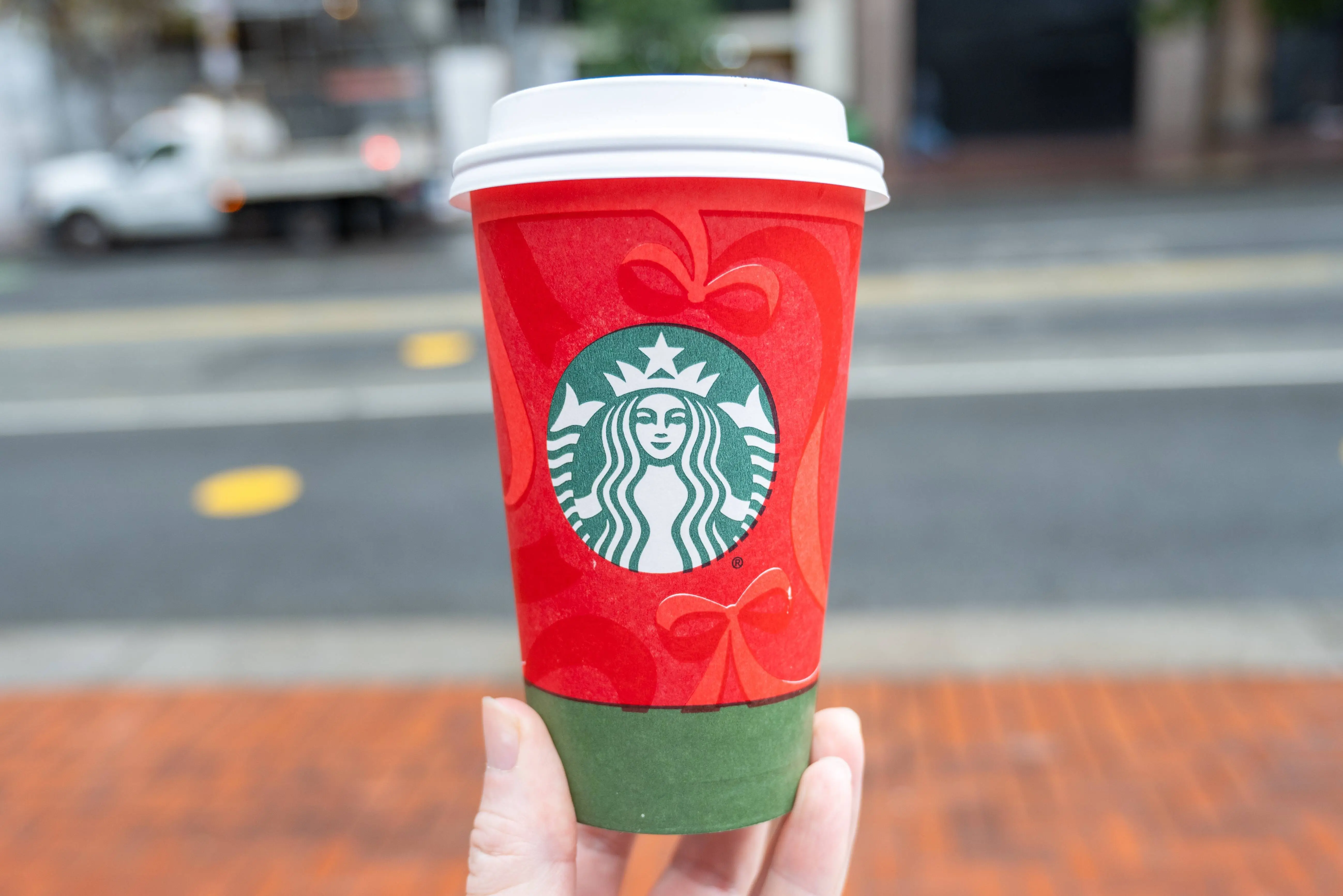 Person's hand holding red and green colored Starbucks holiday cup showing 2025 design, San Francisco, California, November 20, 2025. (Photo by Smith Collection/Gado/Getty Images)