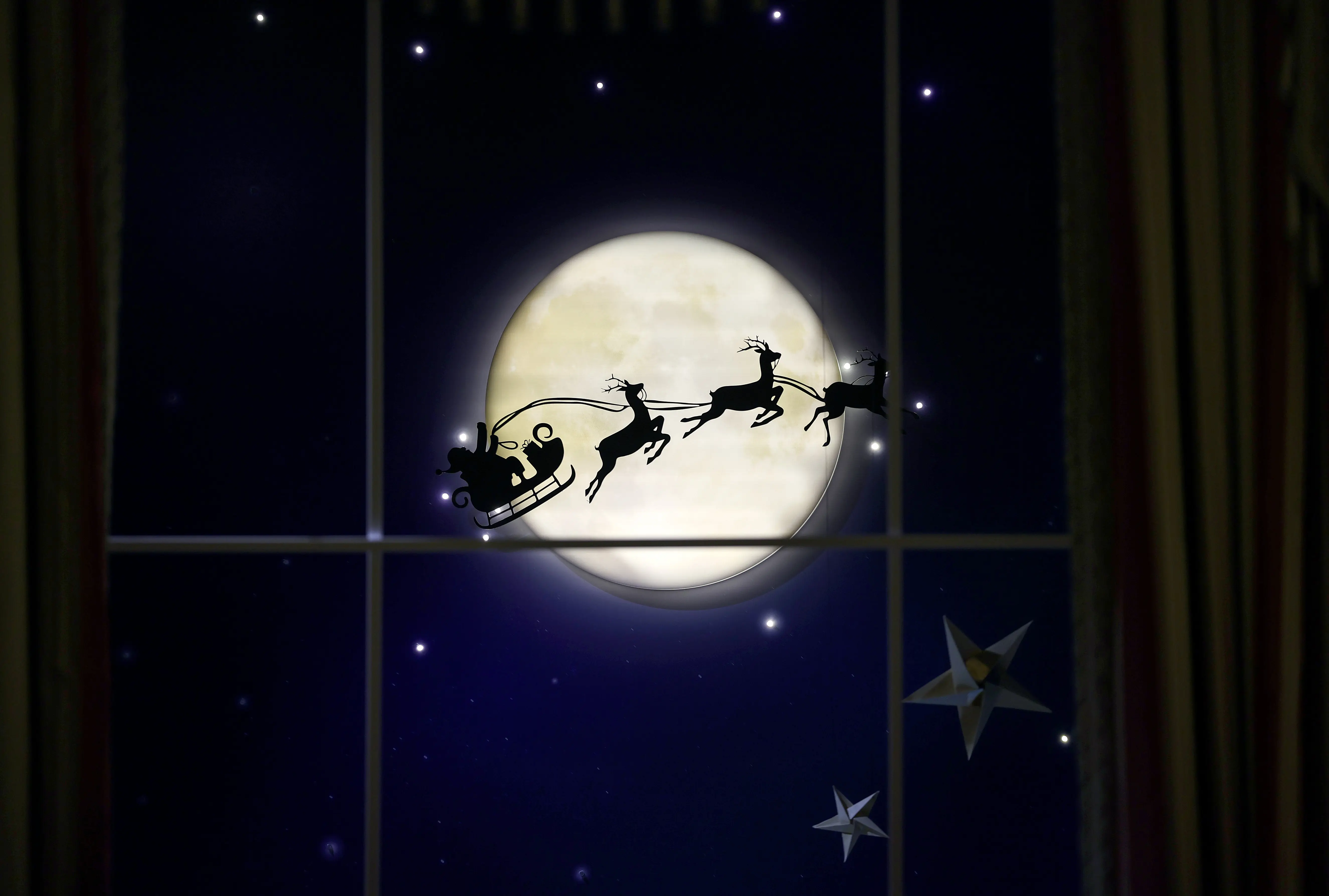 The White House Library is decorated to honor the tradition and magic of bedtime stories, including an image of Santa Claus flying past the moon, during a media preview of the 2023 holiday decorations November 27, 2023 in Washington, DC. The theme for this year's White House decorations is “Magic, Wonder and Joy,” and is designed to capture the “delight and imagination of childhood.” The White House expects to welcome approximately 100,000 visitors during the holiday season. (Photo by Kevin Dietsch/Getty Images)