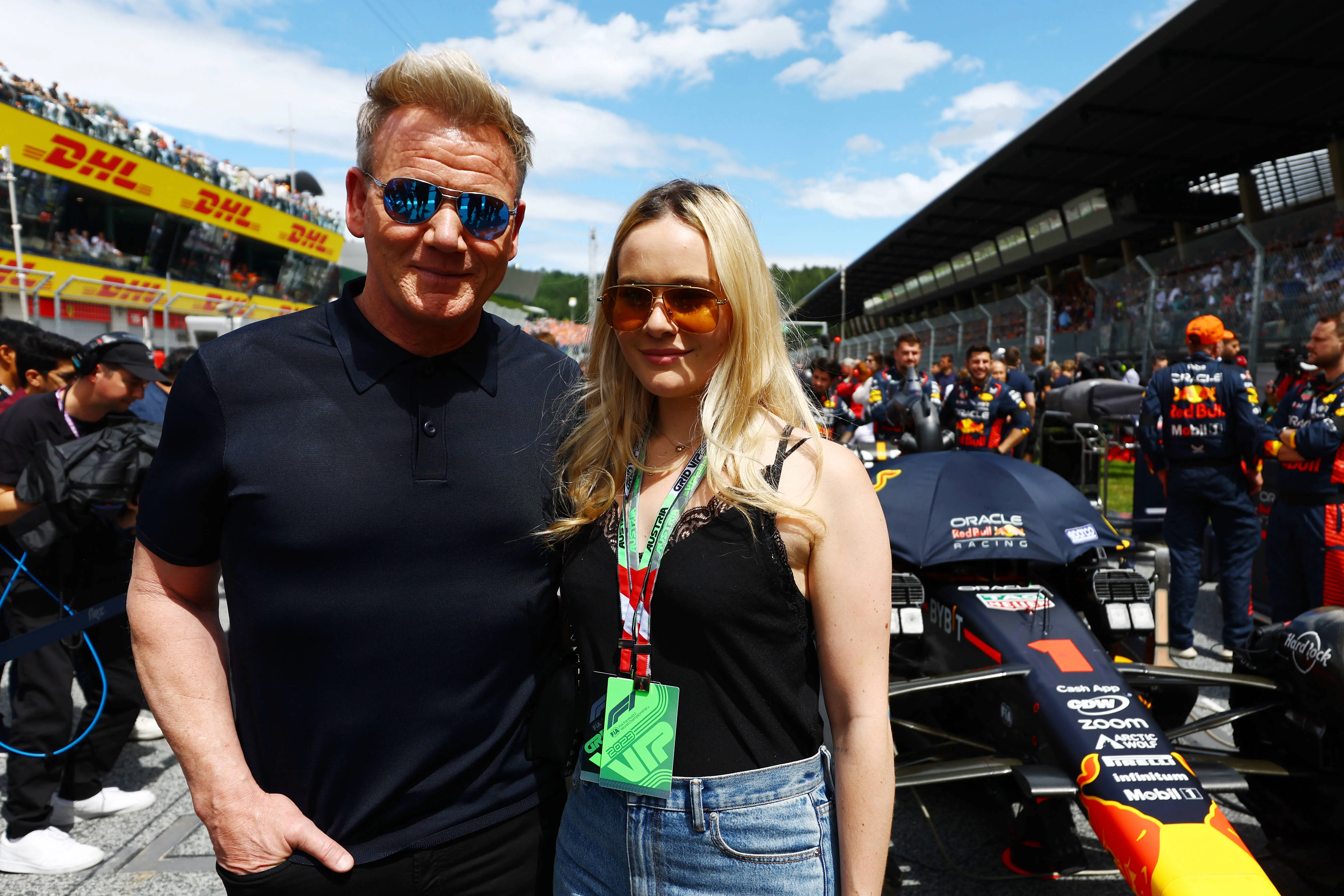 Hell's Kitchen star Gordon Ramsay and Holly Ramsay pose for a photo with the car of Max Verstappen of the Netherlands and Oracle Red Bull Racing on the grid prior to the F1 Grand Prix of Austria at Red Bull Ring on July 02, 2023 in Spielberg, Austria. (Photo by Mark Thompson/Getty Images)