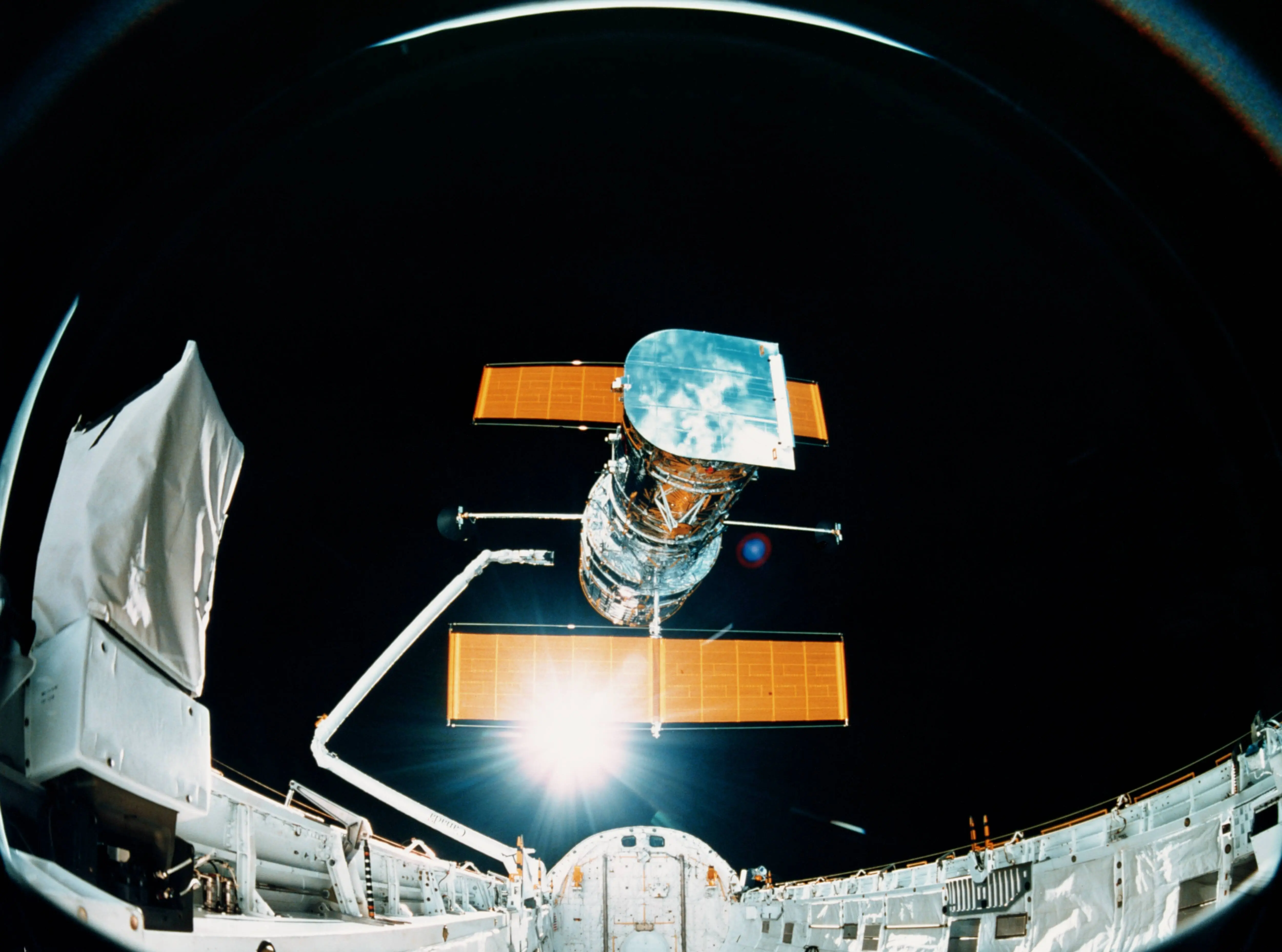 circa 1992:  The Hubble Space Telescope leaving the cargo bay of a NASA space shuttle. The telescope was originally launched in 1990 but docked with Endeavour for repairs to its main mirror in 1993 (Image via Getty)