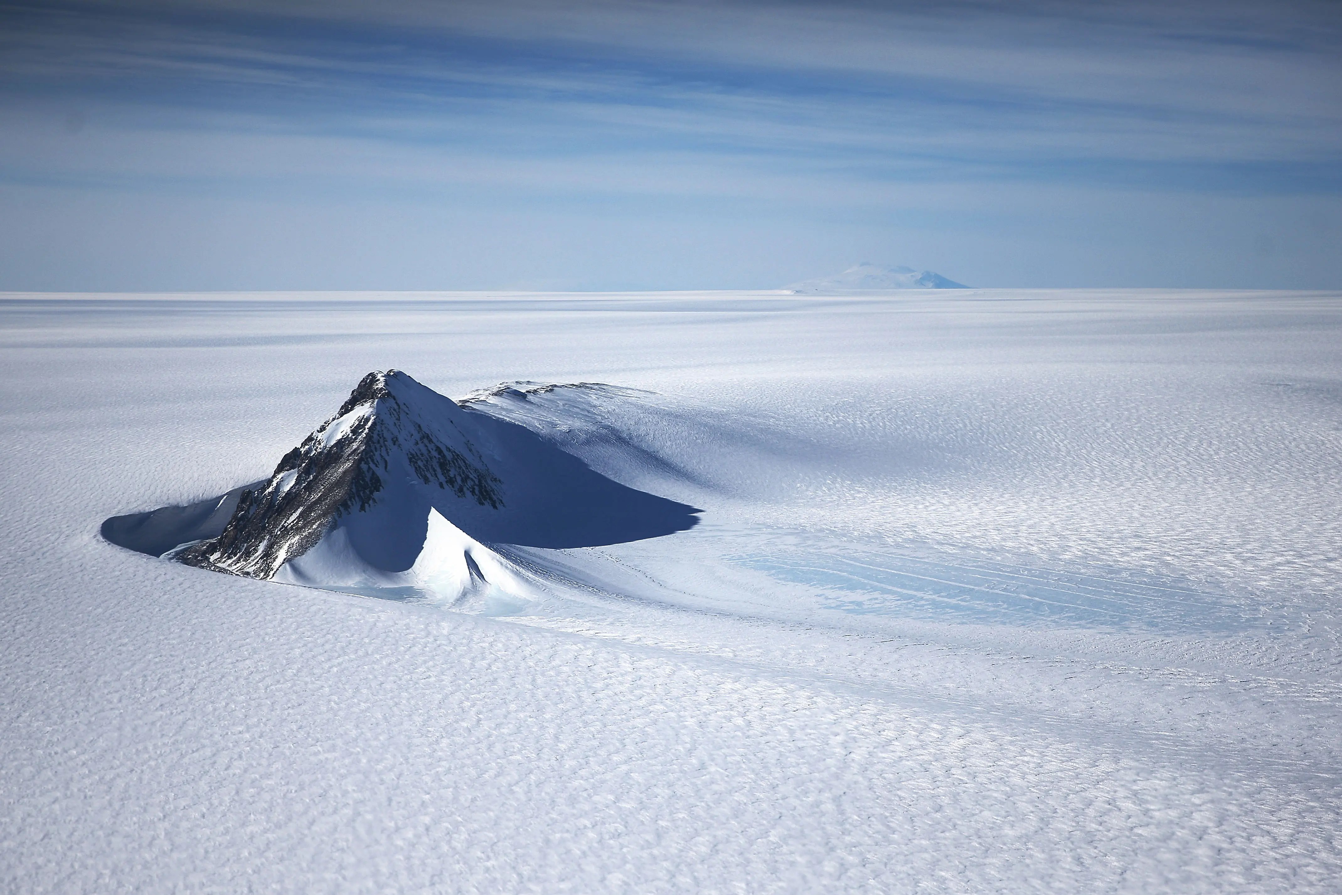 A section of the West Antarctic Ice Sheet with mountains is viewed from a window of a NASA Operation IceBridge airplane (Photo for reference, Image via Getty)