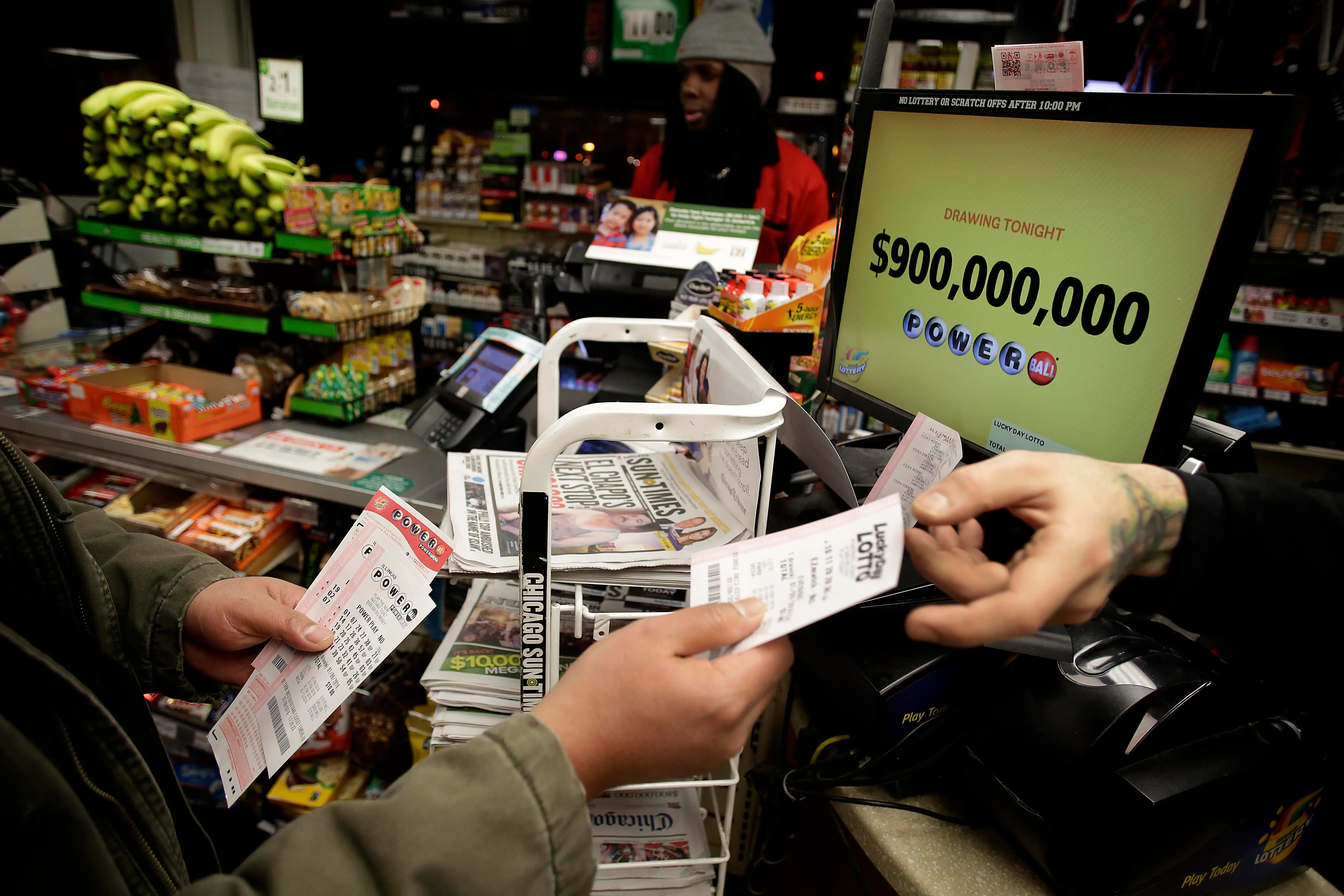 CHICAGO, IL - JANUARY 9 :  A customer receives Powerball tickets from a clerk at a 7-Eleven store January 9, 2016 in Chicago, Illinois. The Powerball Jackpot Surged to a record $900 Million in 44 States, Washington D.C., Puerto Rico, and the US Virgin Islands before tonight's drawing. (Photo by Joshua Lott/Getty Images)