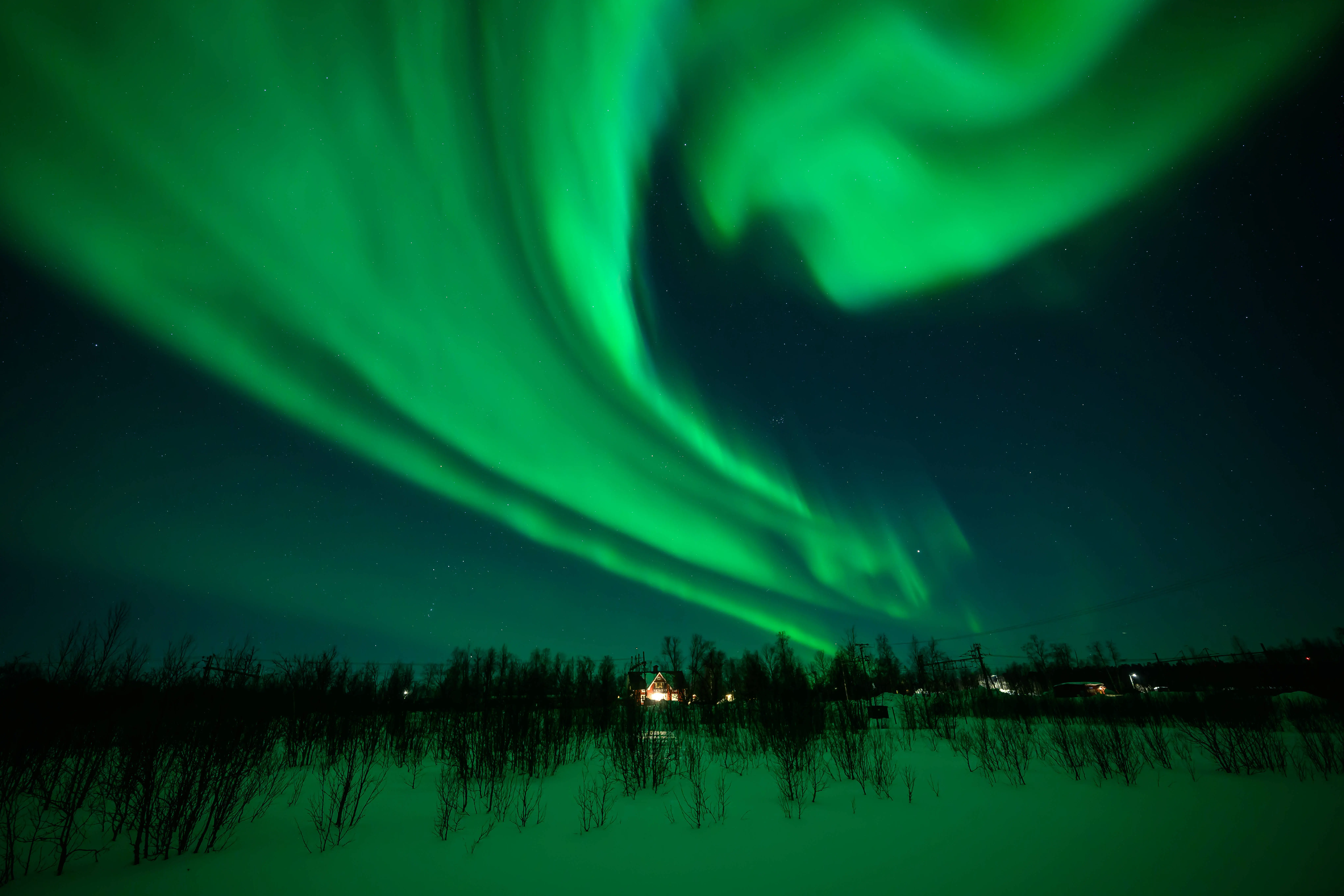 The Aurora Borealis, commonly known as the Northern Lights, are seen in the sky above Kiruna on March 7, 2024 in Kiruna, Sweden. The area is widely regarded as one of the best places in the world to see the phenomenon, which occurs when energized particles from the sun hit the Earth's upper atmosphere (Image via Getty)