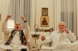 Cardinal Bergoglio (Jonathan Pryce) and Pope Benedict (Anthony Hopkins) take a break from debating the church's future to enjoy some sport on TV. (Netflix)