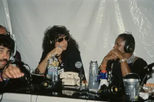 American radio host and 'shock jock' Howard Stern, wearing a black t-shirt with a gun motif and sunglasses, and his co-host, American radio host Robin Quivers, who wears a black sleeveless haltertop with a jewel-encrusted collar, recording of 'The Howard Stern Show' in WXRK, in New York City, New York, circa 1995. (Photo by Vinnie Zuffante/Getty Images)