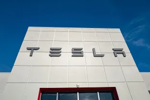 Low-angle view of the facade of Tesla Motors dealership with logo and sign in Pleasanton, California, July 23, 2018. (Photo by Smith Collection/Gado/Getty Images)